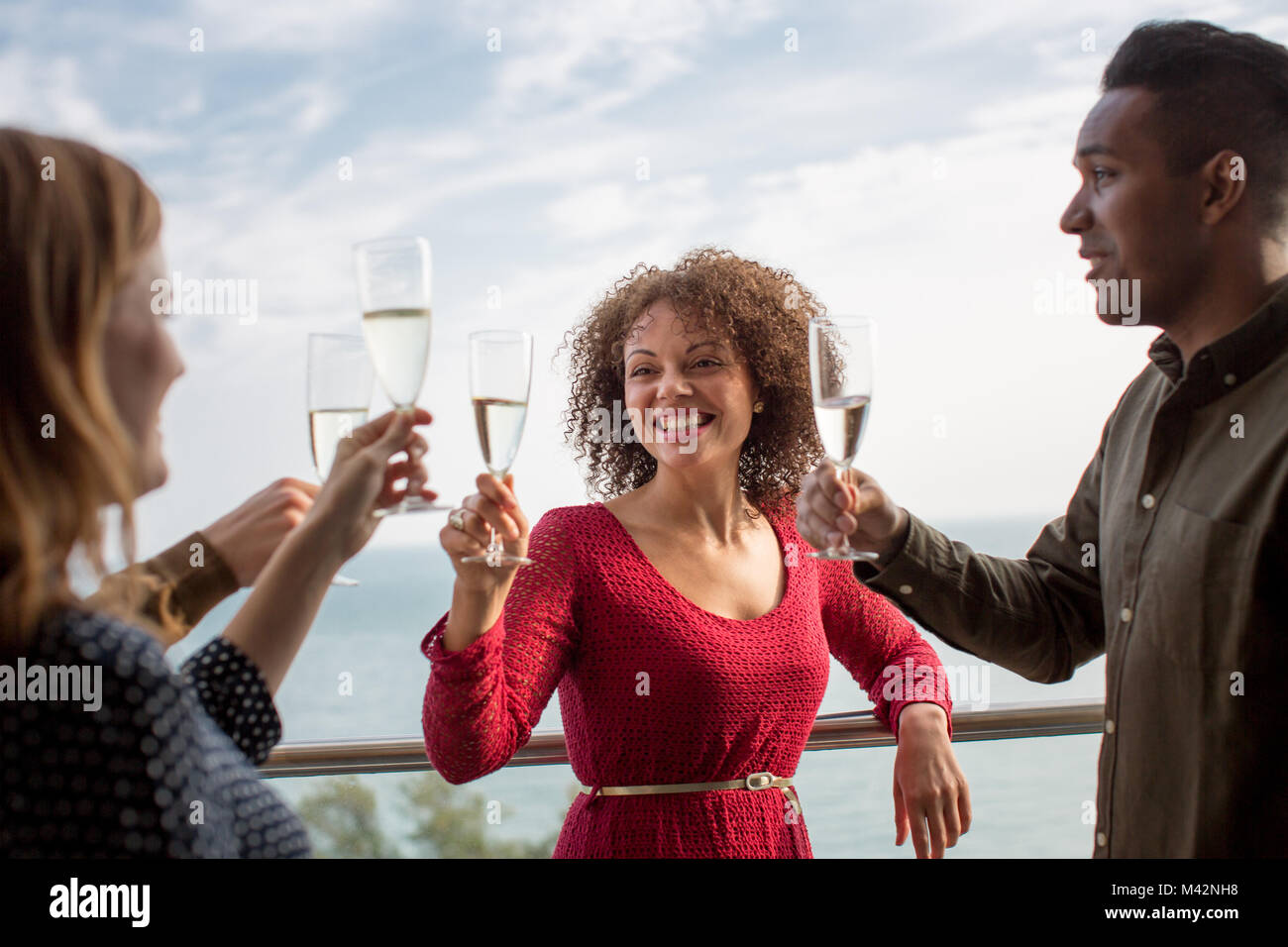 Amigos, disfrutando de las vistas desde el balcón del mar Foto de stock