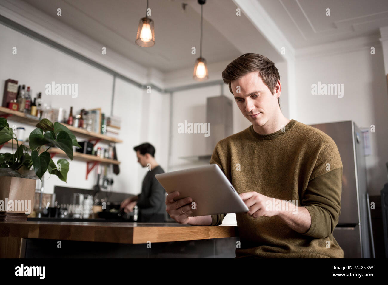 Macho joven con tableta digital en casa Foto de stock