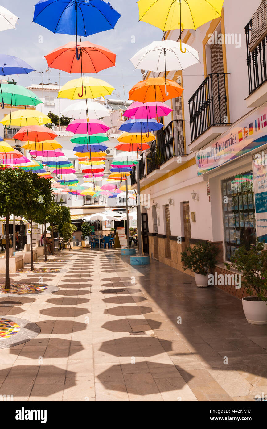 Una imagen de un típico pueblo español en un cálido día de verano, con adición de paraguas para crear una zona de sombra y colorido Fotografía de stock - Alamy