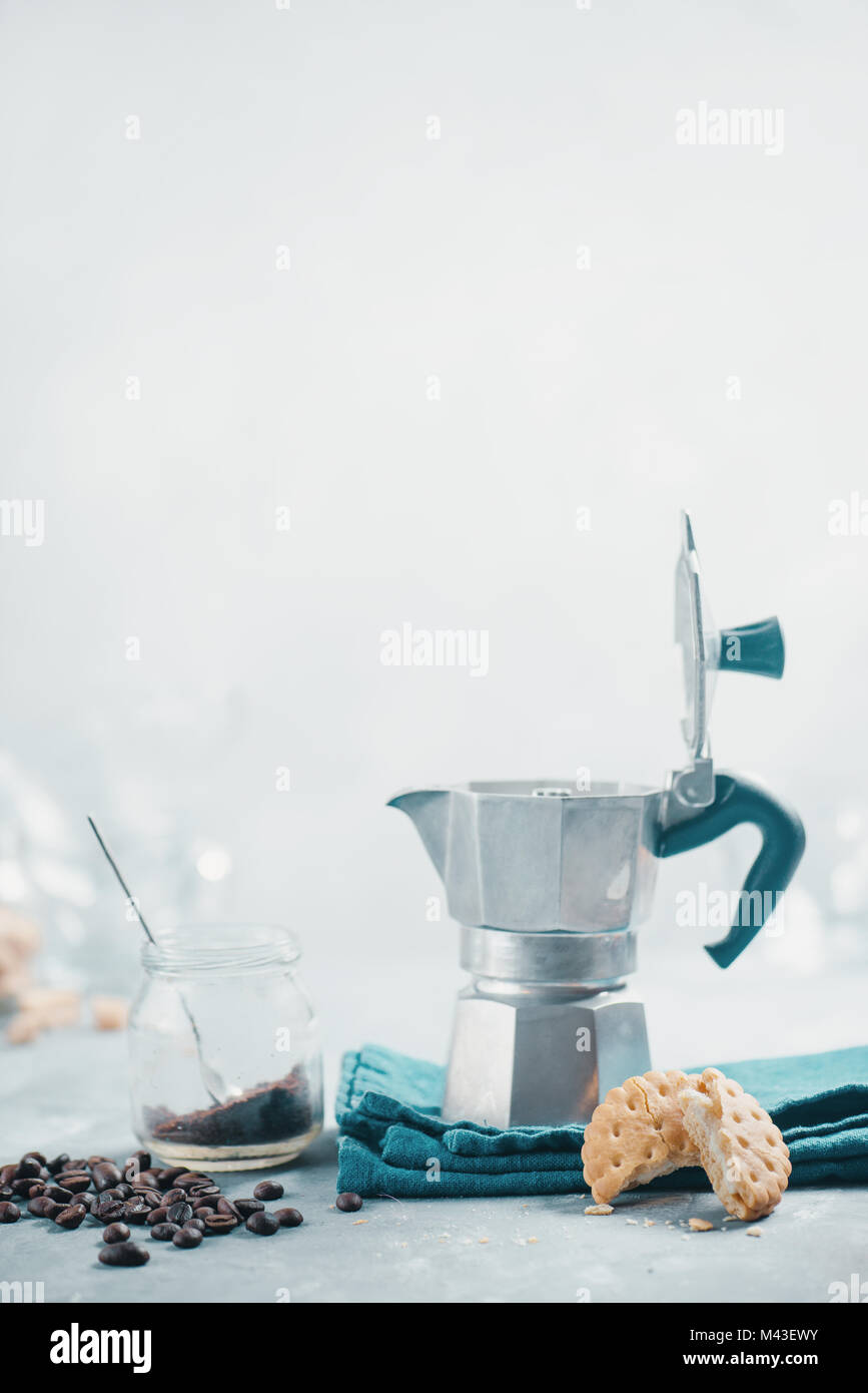 Concepto de café y galletas. Moka olla sobre un fondo de hormigón ligero con galletas y café. Concepto de tercera ola. Foto de stock
