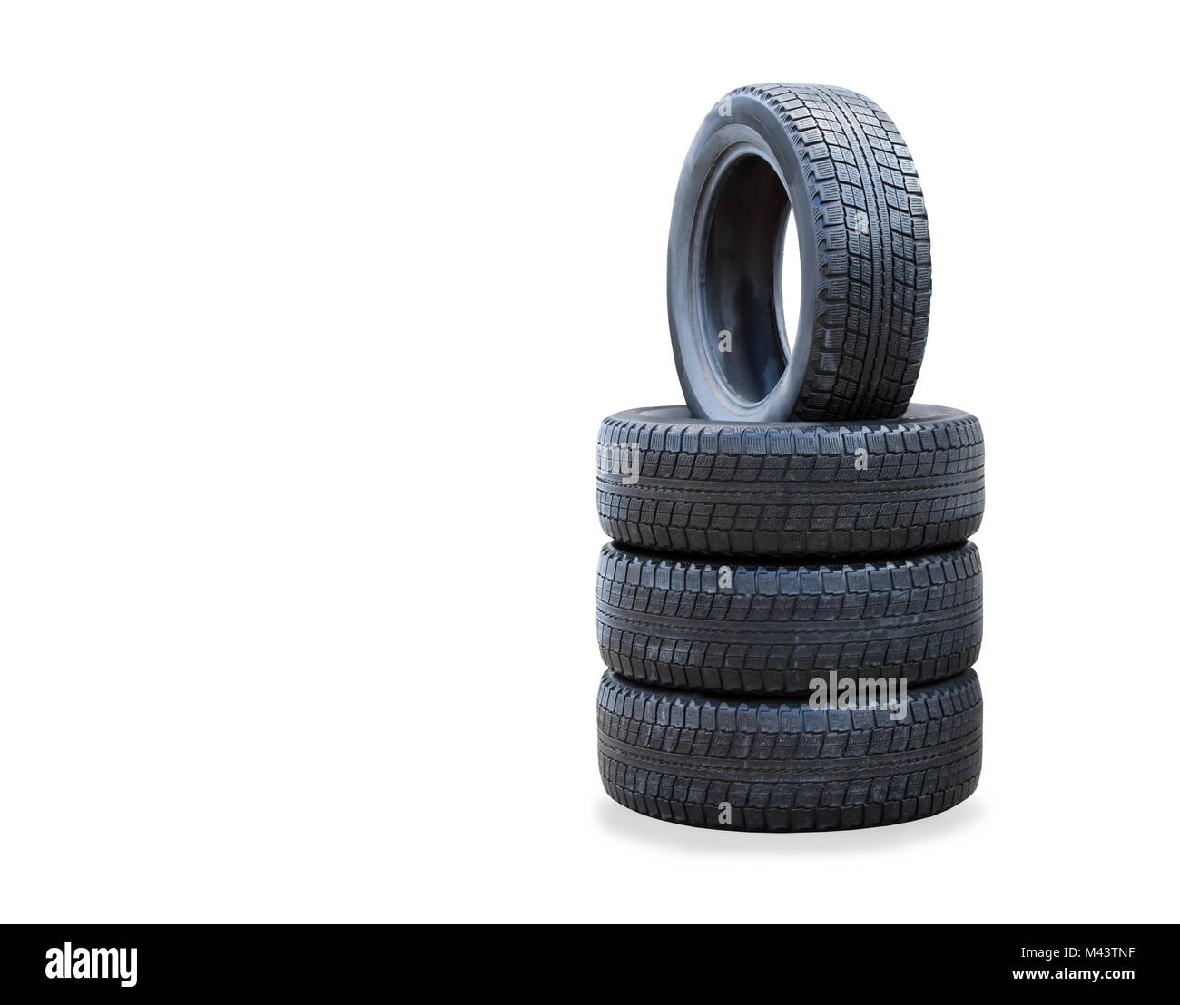 La pila de cuatro nuevos neumáticos de invierno sobre blanco Foto de stock