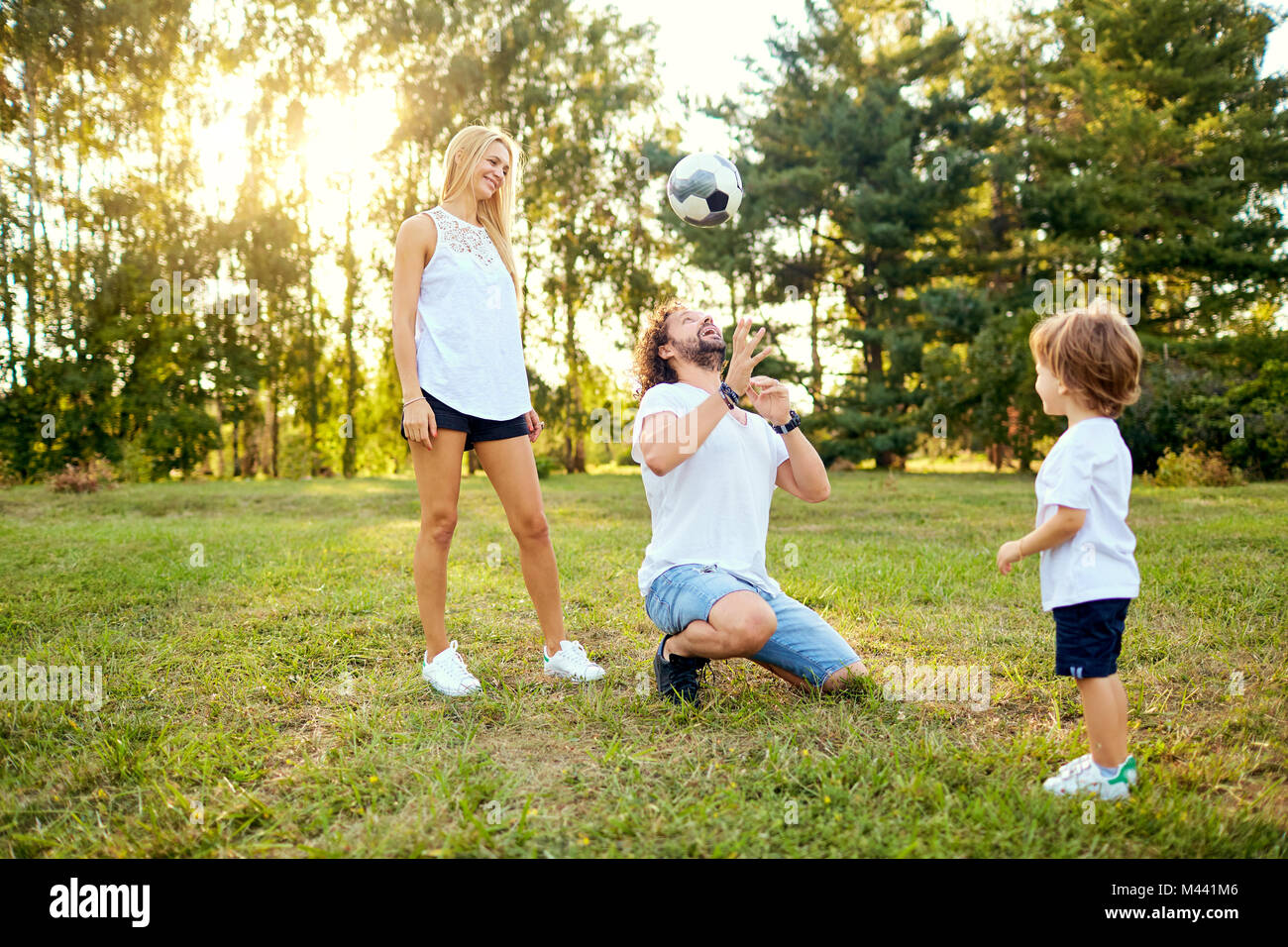 Familia jugando con la pelota en el parque. Foto de stock