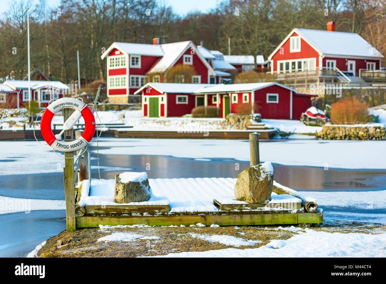 Bokevik, Suecia - 7 de febrero de 2018: Documental de la vida cotidiana y el medio ambiente. Salvavidas y pier por el pueblo pesquero con helado de bahía y el invierno Foto de stock