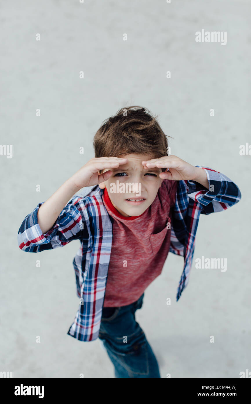 Retrato de un joven chico mirando a la cámara y el blindaje de sus ojos Foto de stock