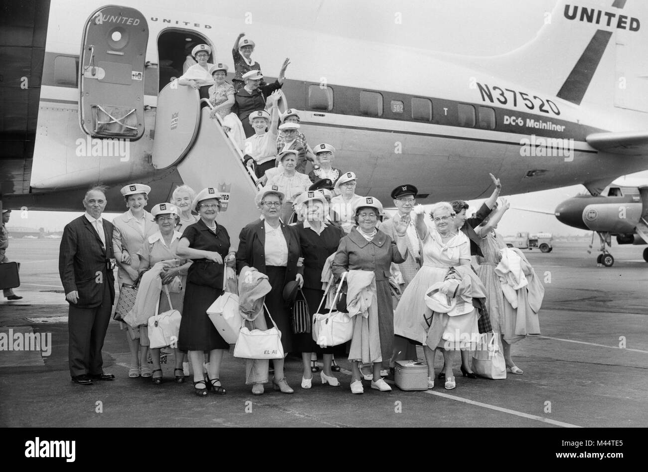 Un grupo de ancianos excursión a bordo de un vuelo de United Airlines en Chicago para una gira por Europa, ca. 1962. Foto de stock