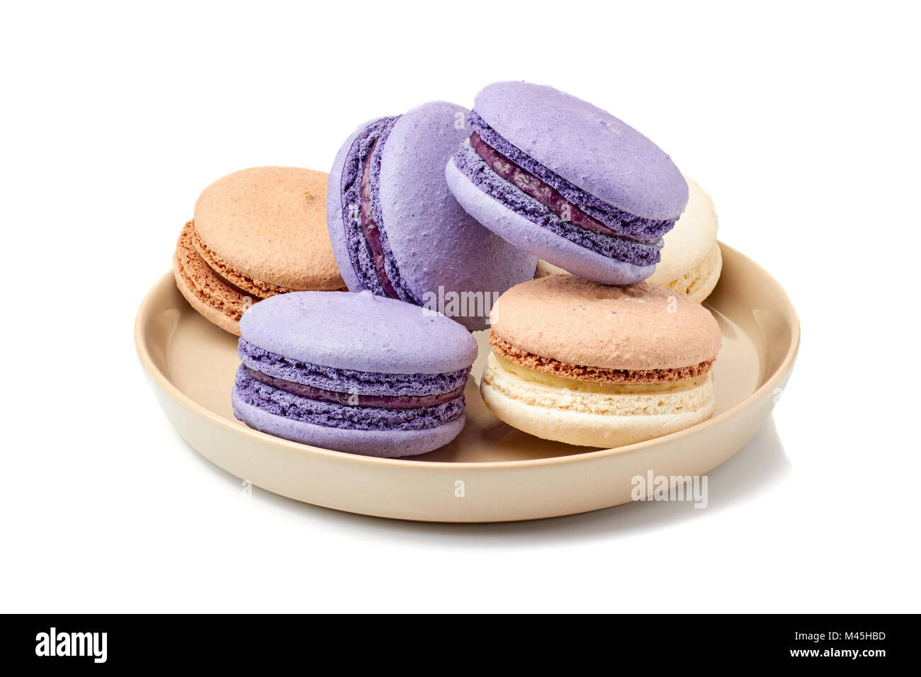 Vith placa violeta y macarons beige sobre blanco Foto de stock