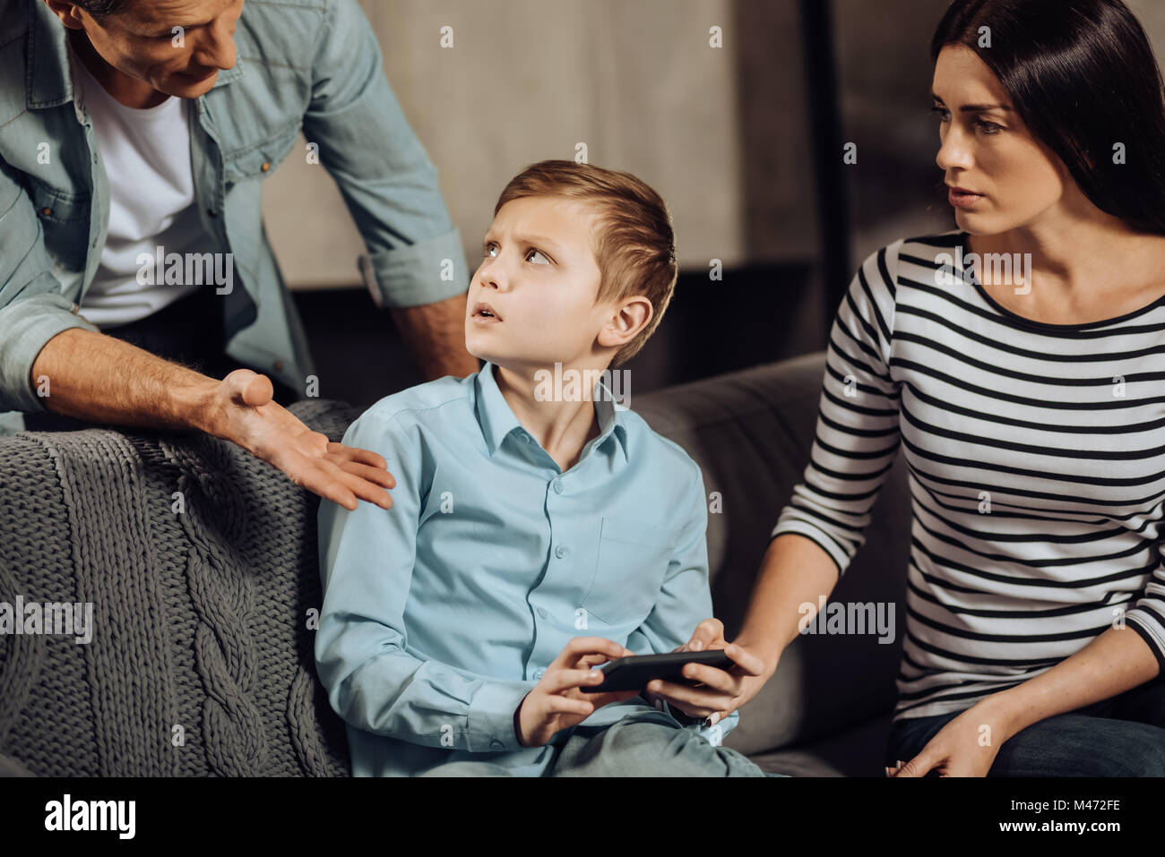 Padre joven regañar a su hijo por atracón-jugando Foto de stock