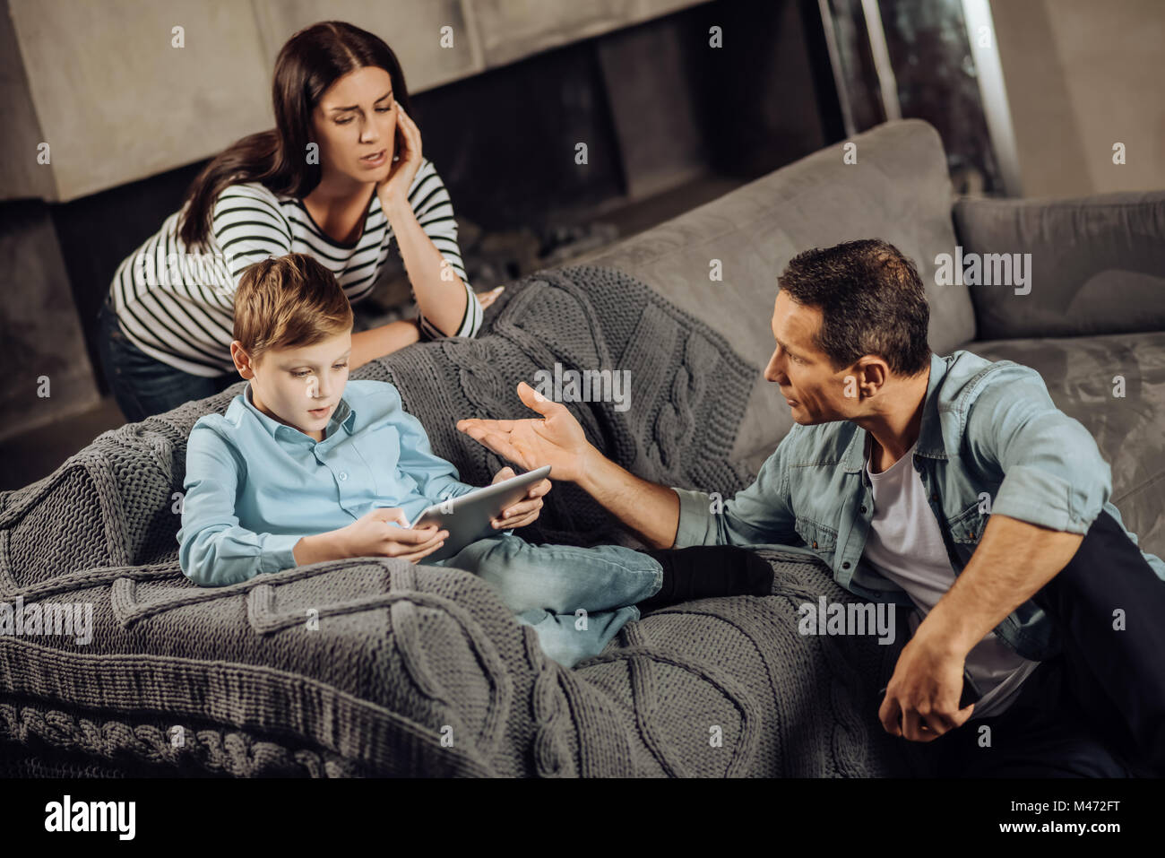 Hijo de padres interesados sermoneando sobre perjuicios de atracón-jugando Foto de stock