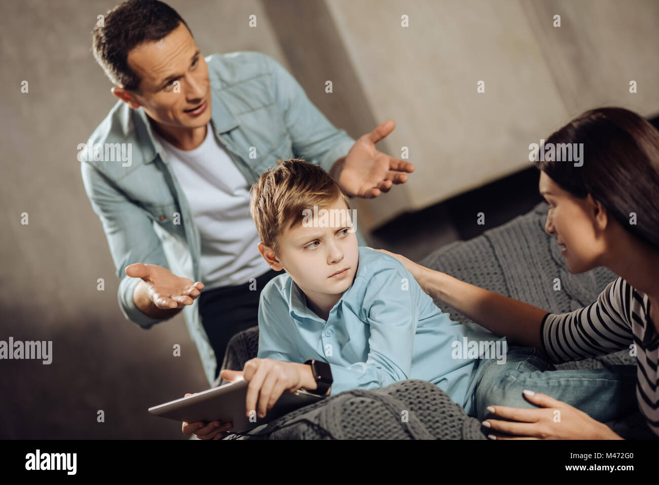Pre-teen boy evidentes a los padres interrumpir su juego Foto de stock