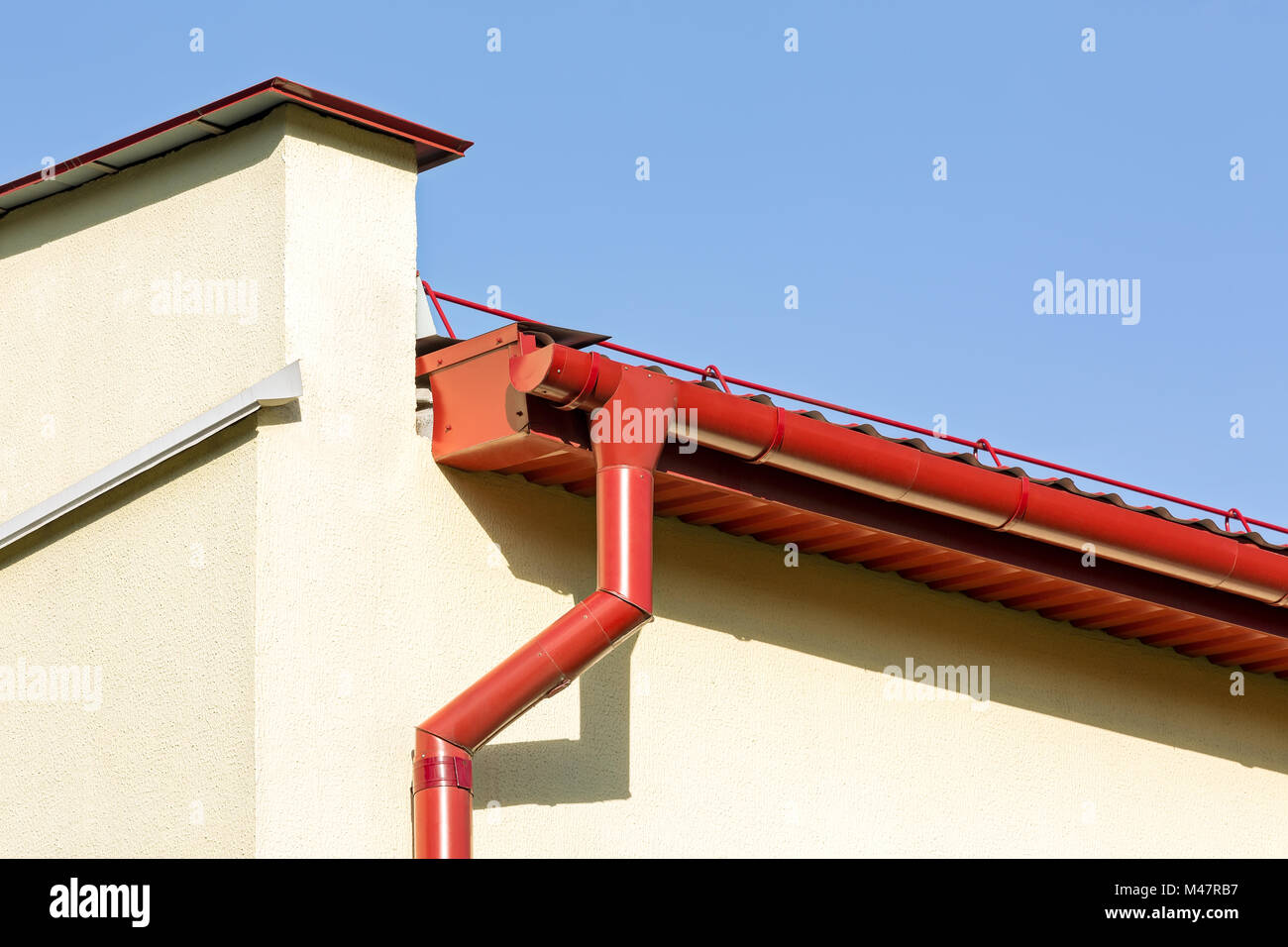 Canalones tejado rojo con tubo de bajante Fotografía de stock - Alamy