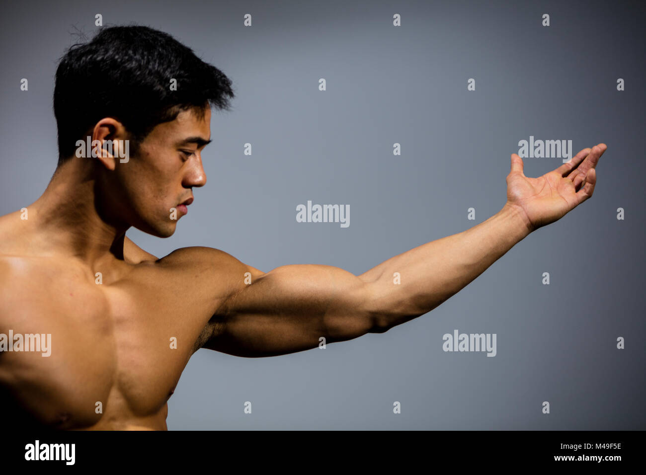 Un modelo de fitness con un brazo estirado mostrando su músculo bíceps.  Perfil Fotografía de stock - Alamy
