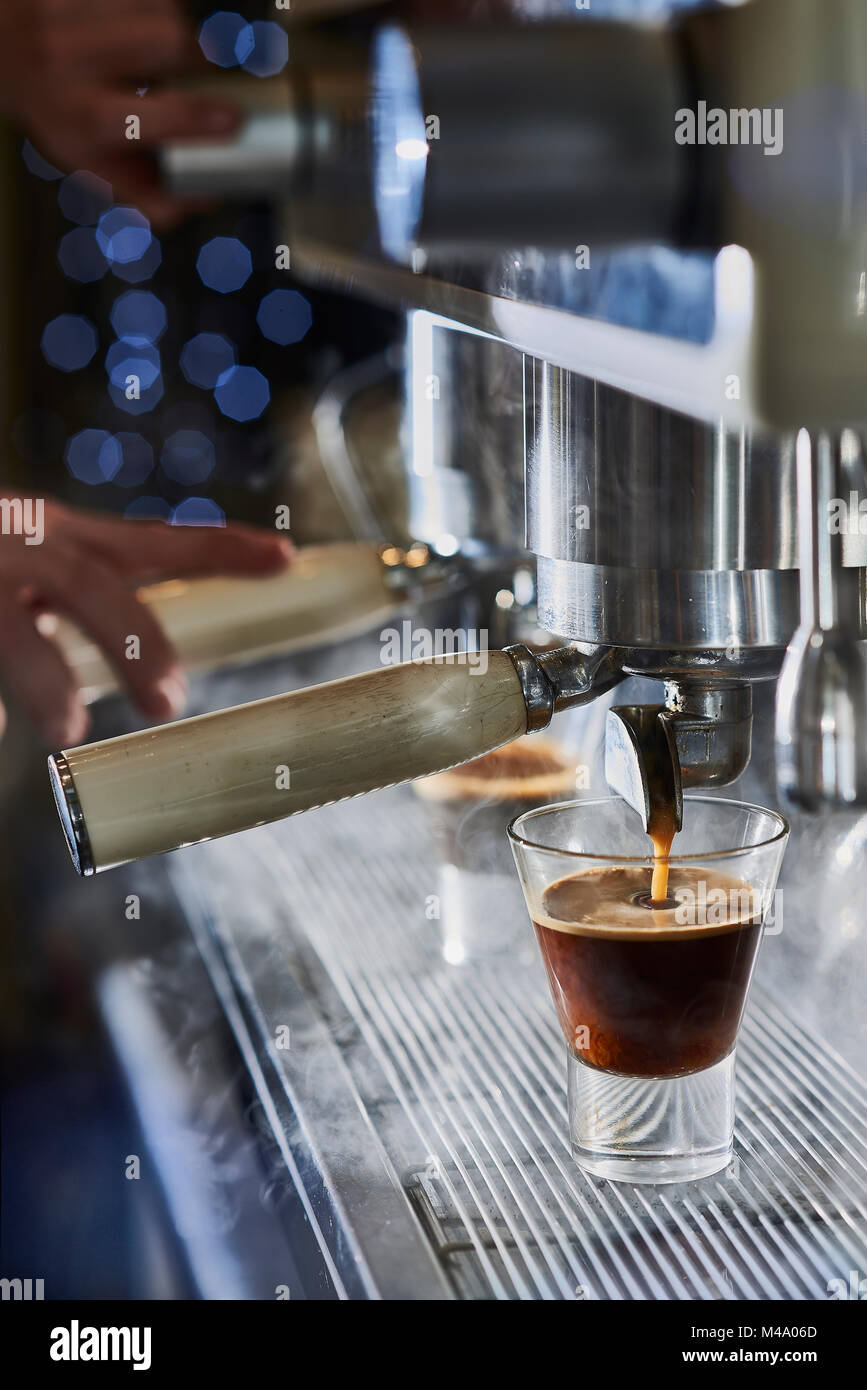 Barista haciendo un espresso con una cafetera italiana clásica con vapor en  segundo plano Fotografía de stock - Alamy