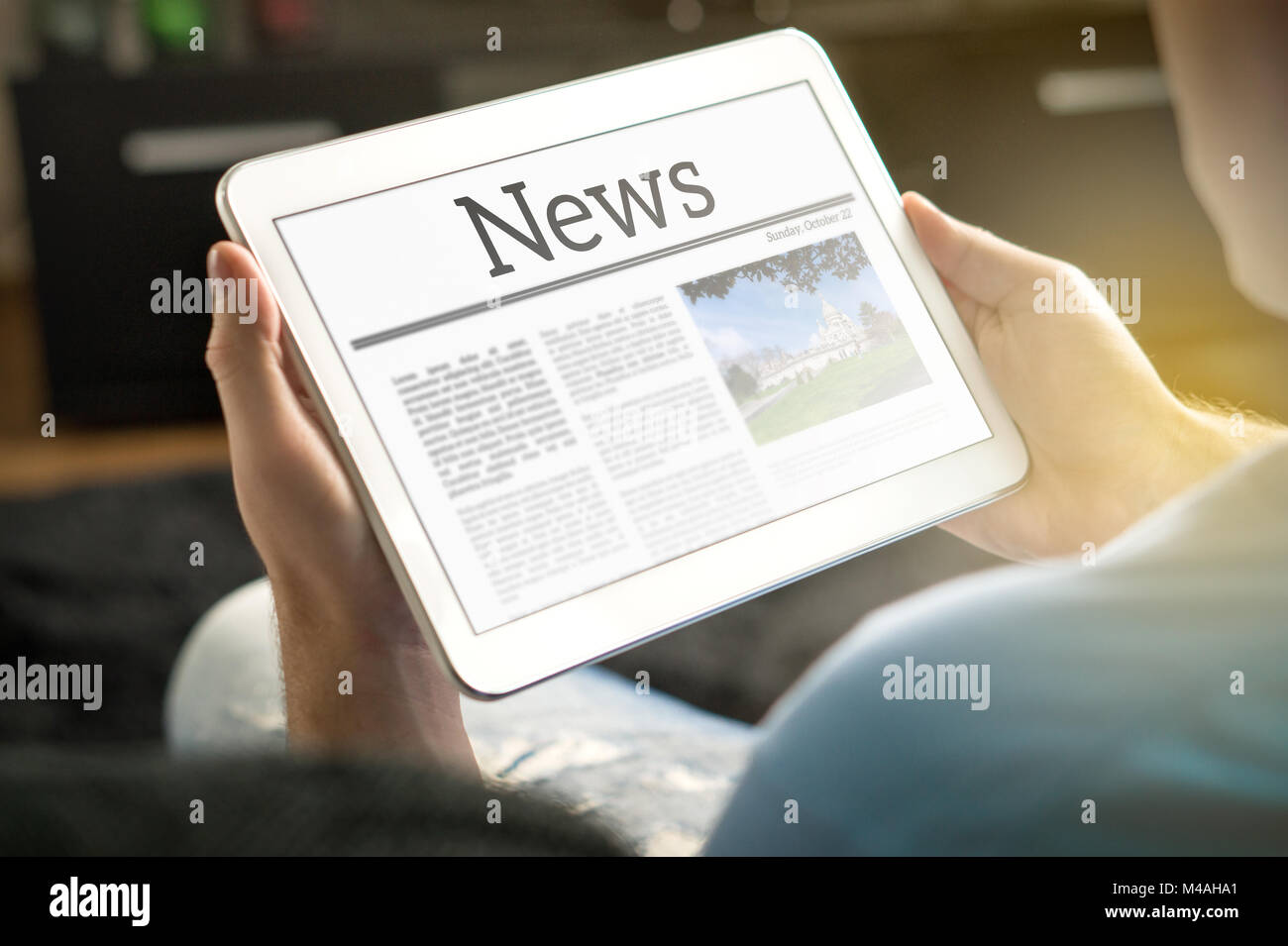 Hombre leyendo las noticias sobre tablet en casa. Línea imaginaria y móvil noticias Sitio web, aplicación o portal en la moderna pantalla táctil. Foto de stock