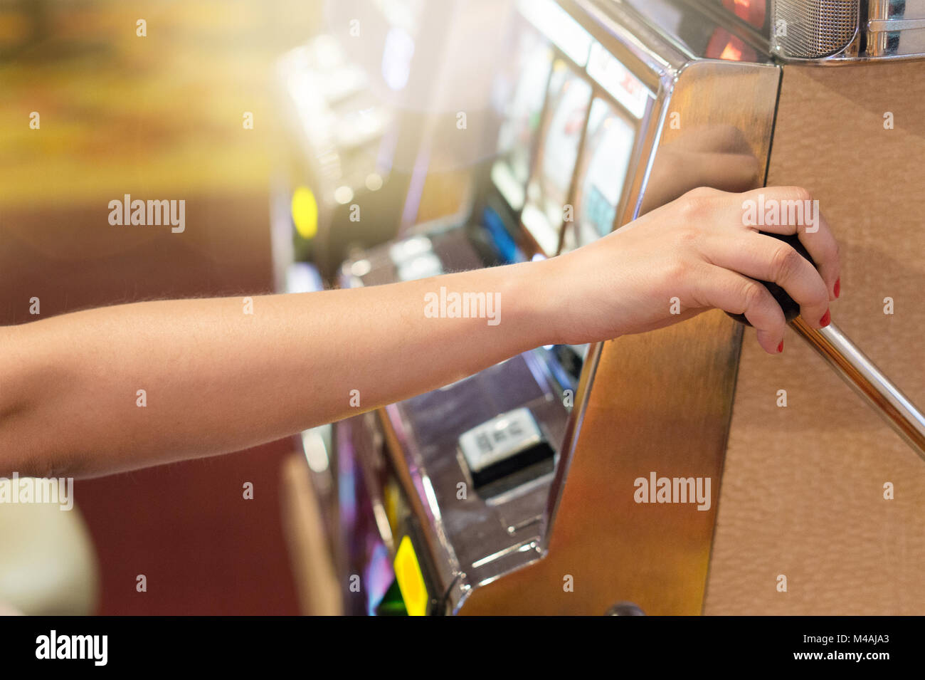 Mujer tirando de la manivela de la máquina de ranura en un casino. Los juegos de azar, la suerte, tomando riesgos y ganar el jackpot concepto. Gambler jugando en Las Vegas. Foto de stock