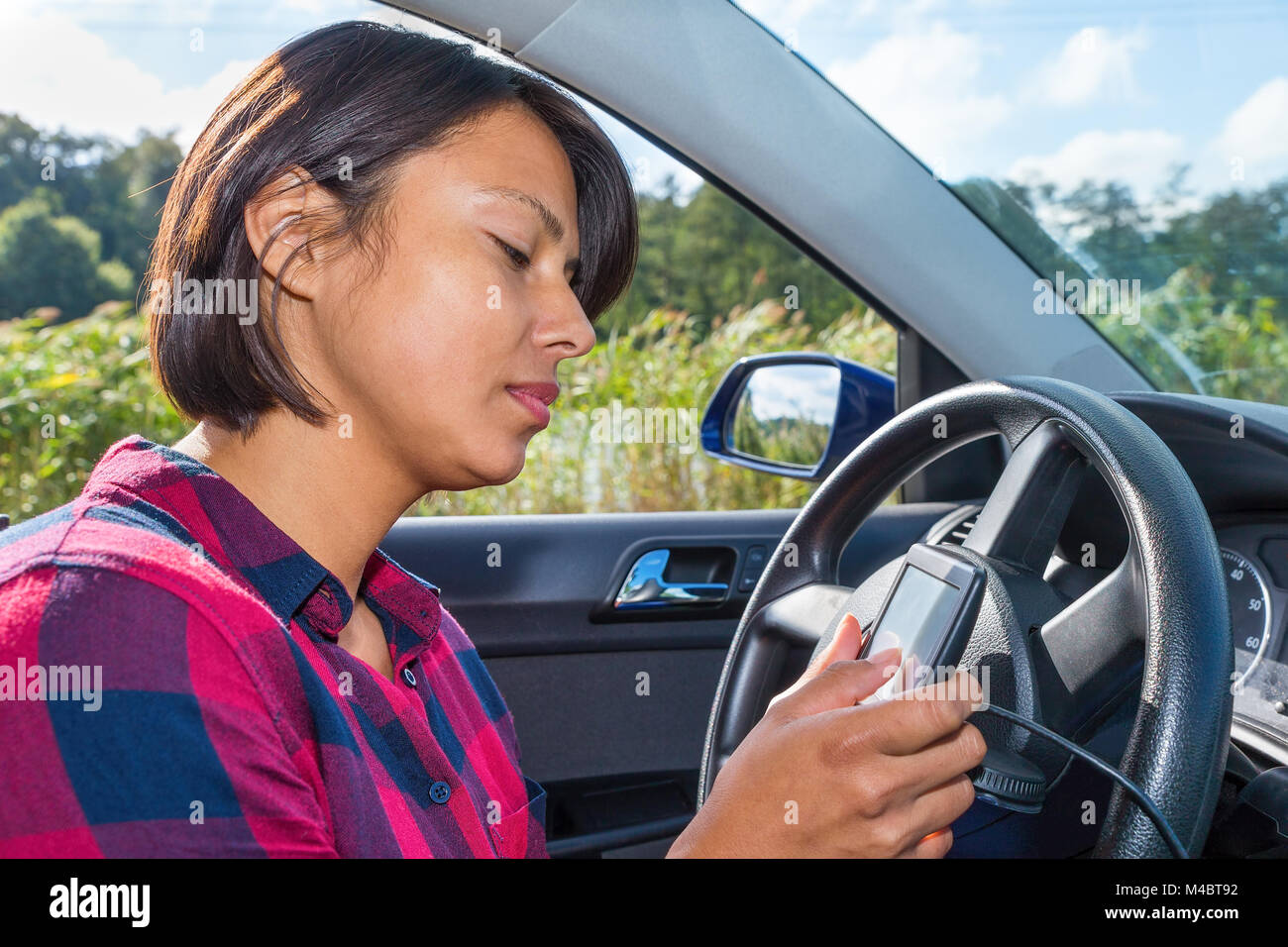 Mujer joven opera electronic planificador de ruta en coche Foto de stock