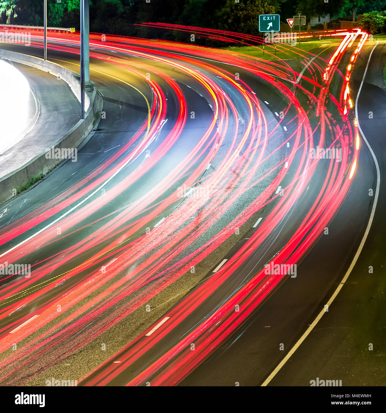 Conmutar el tráfico de vehículos en la carretera por la noche Foto de stock