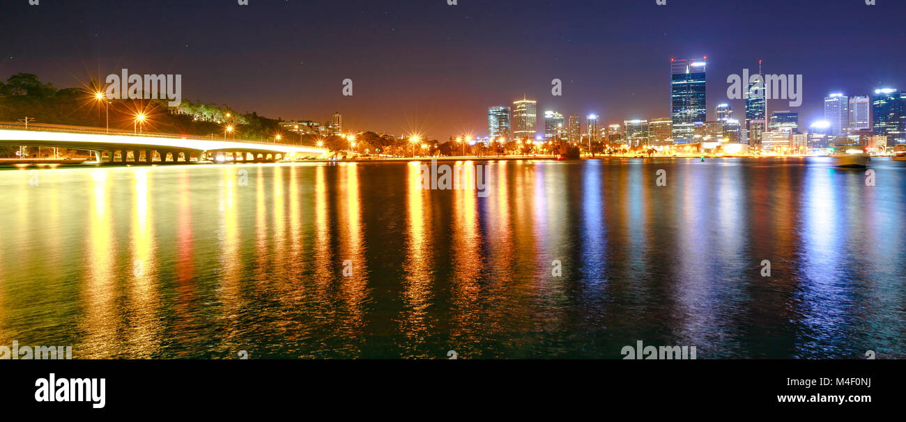 Panorama del puente Angostura y ciudad de Perth iluminados durante la noche. Perth centro ciudad con rascacielos reflexionando sobre el Río Swan de Mill Point, Australia Occidental. Foto de stock