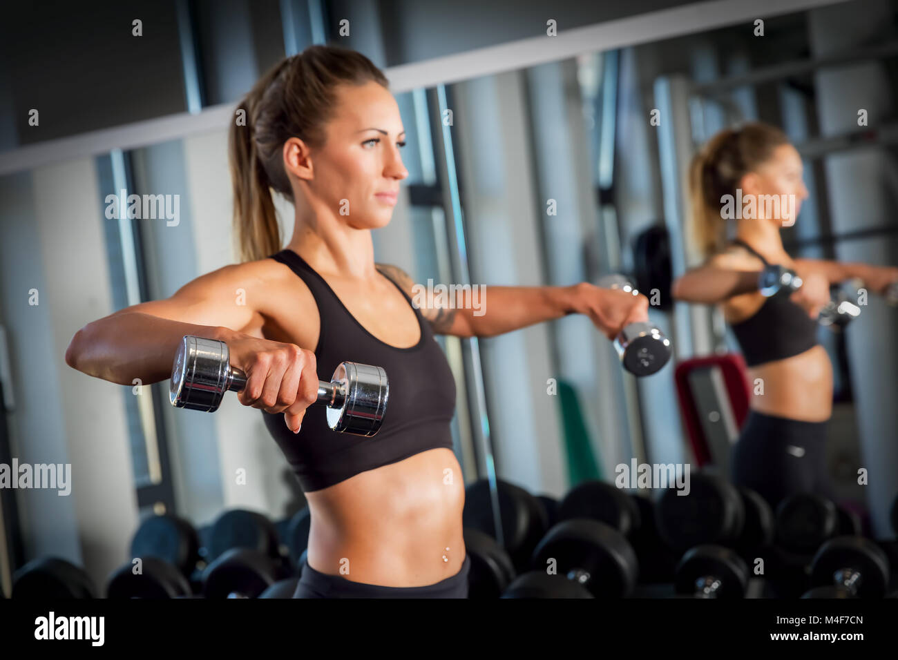 Mujer atractiva de levantamiento de pesas en el gimnasio. Foto de stock