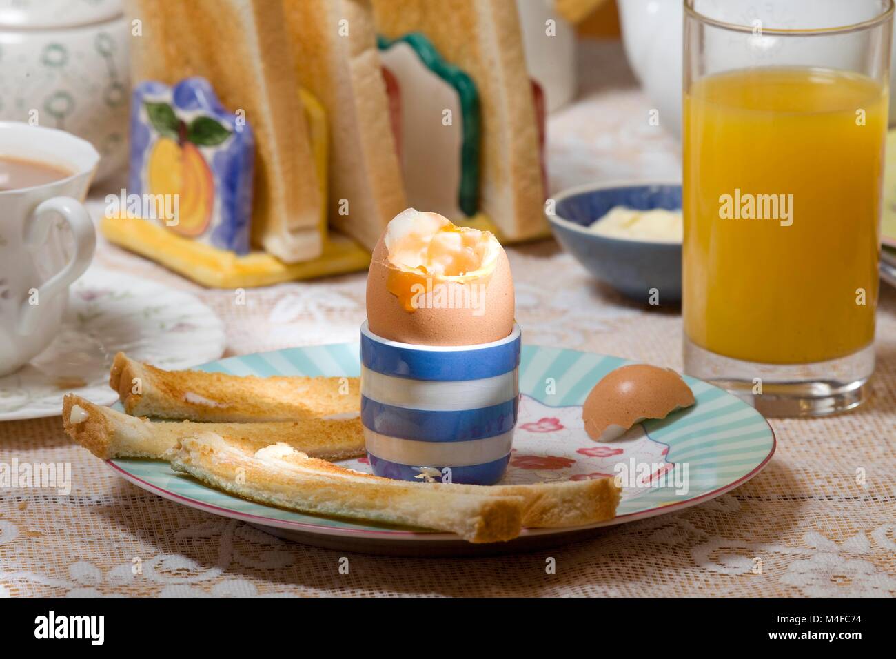 Ajuste de desayuno con huevo y tostadas con mantequilla Foto de stock