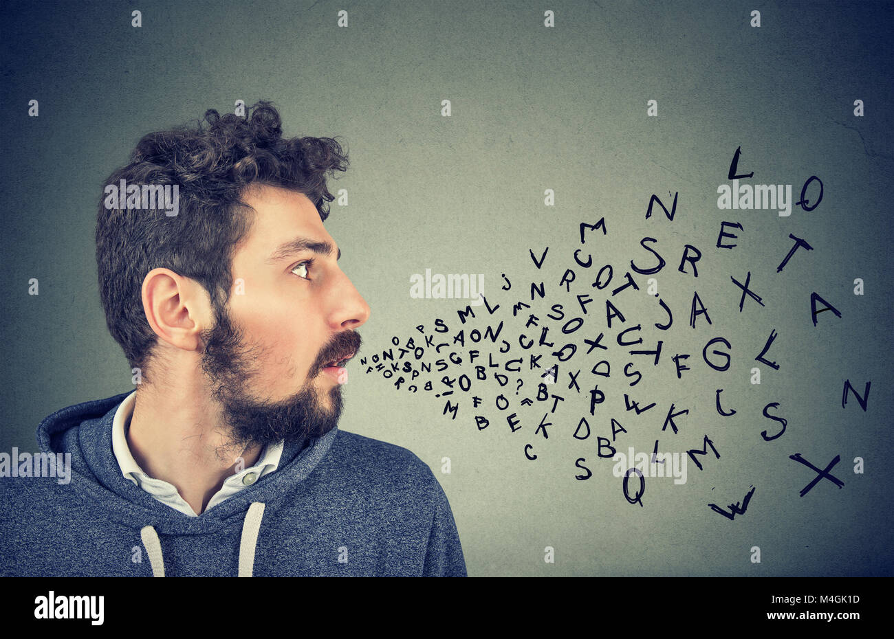Hombre hablando con las letras del alfabeto que sale de su boca. La comunicación, la información, el concepto de inteligencia Foto de stock