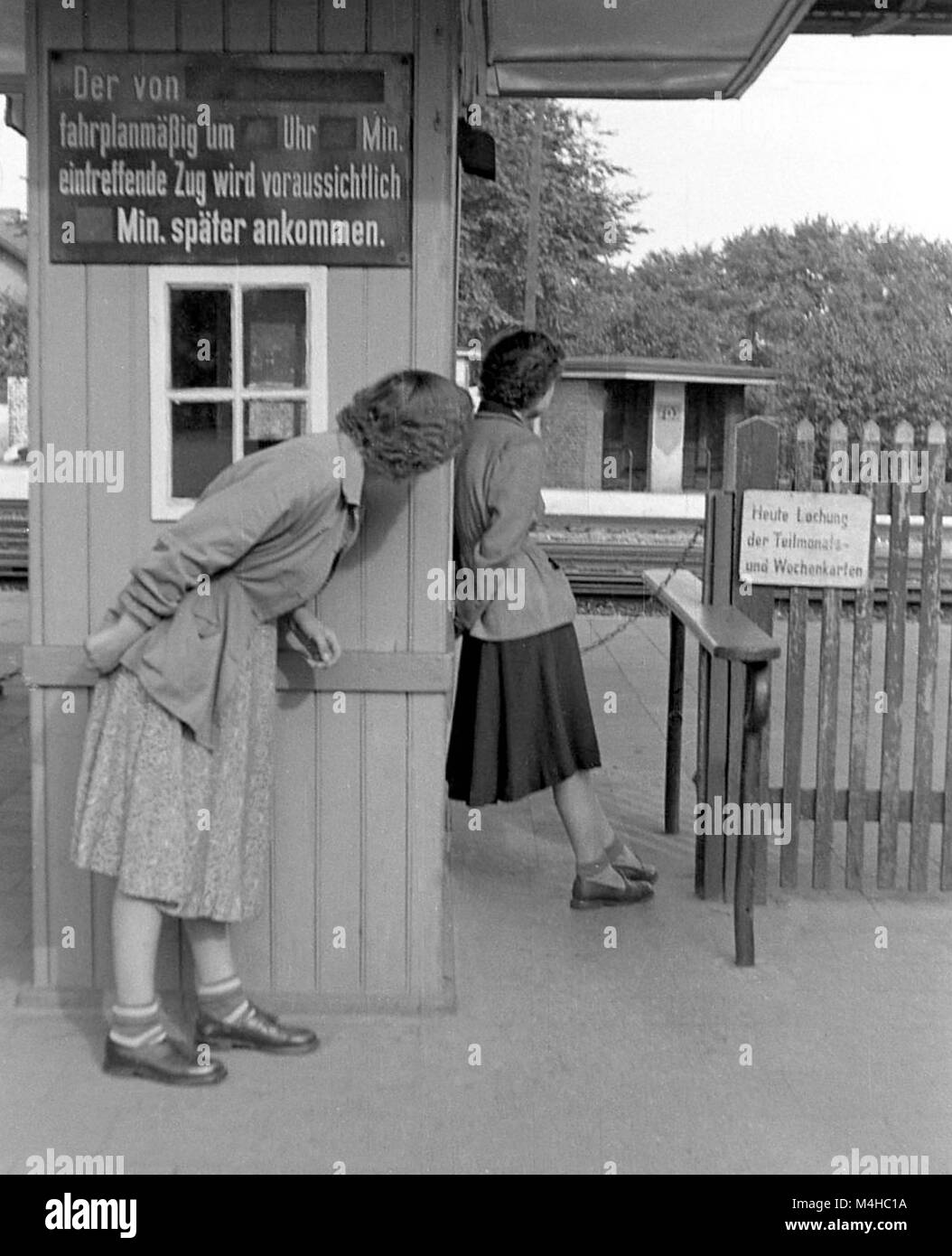 Dos niñas están esperando un tren en la estación de Warnemuende, un  distrito de Rostock. En una pizarra, figura la inscripción "el tren que  según el calendario debe llegar a .... o'clock,