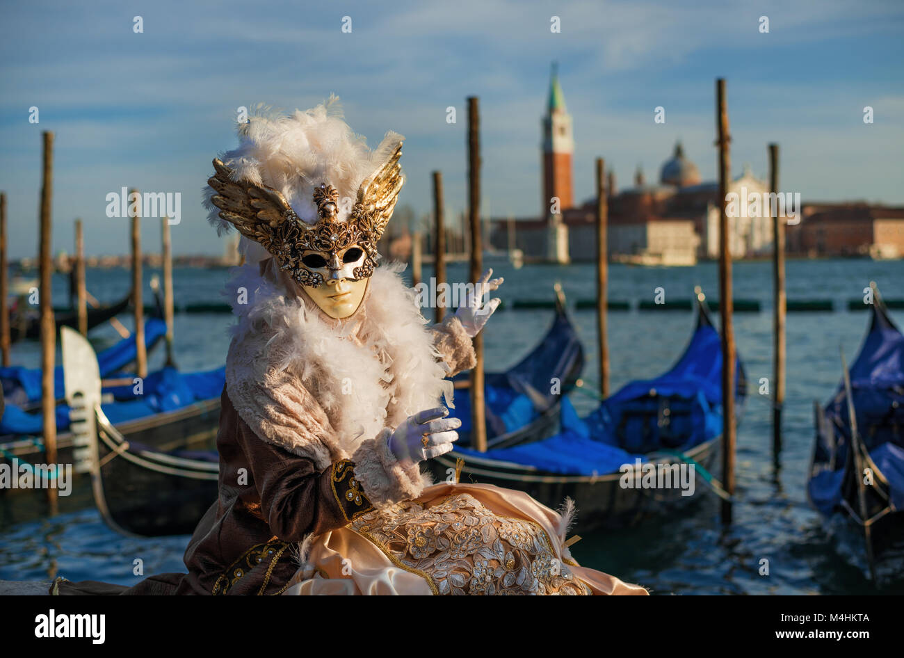 La máscara de carnaval con la hermosa Laguna de Venecia y la góndola en el fondo al atardecer Foto de stock