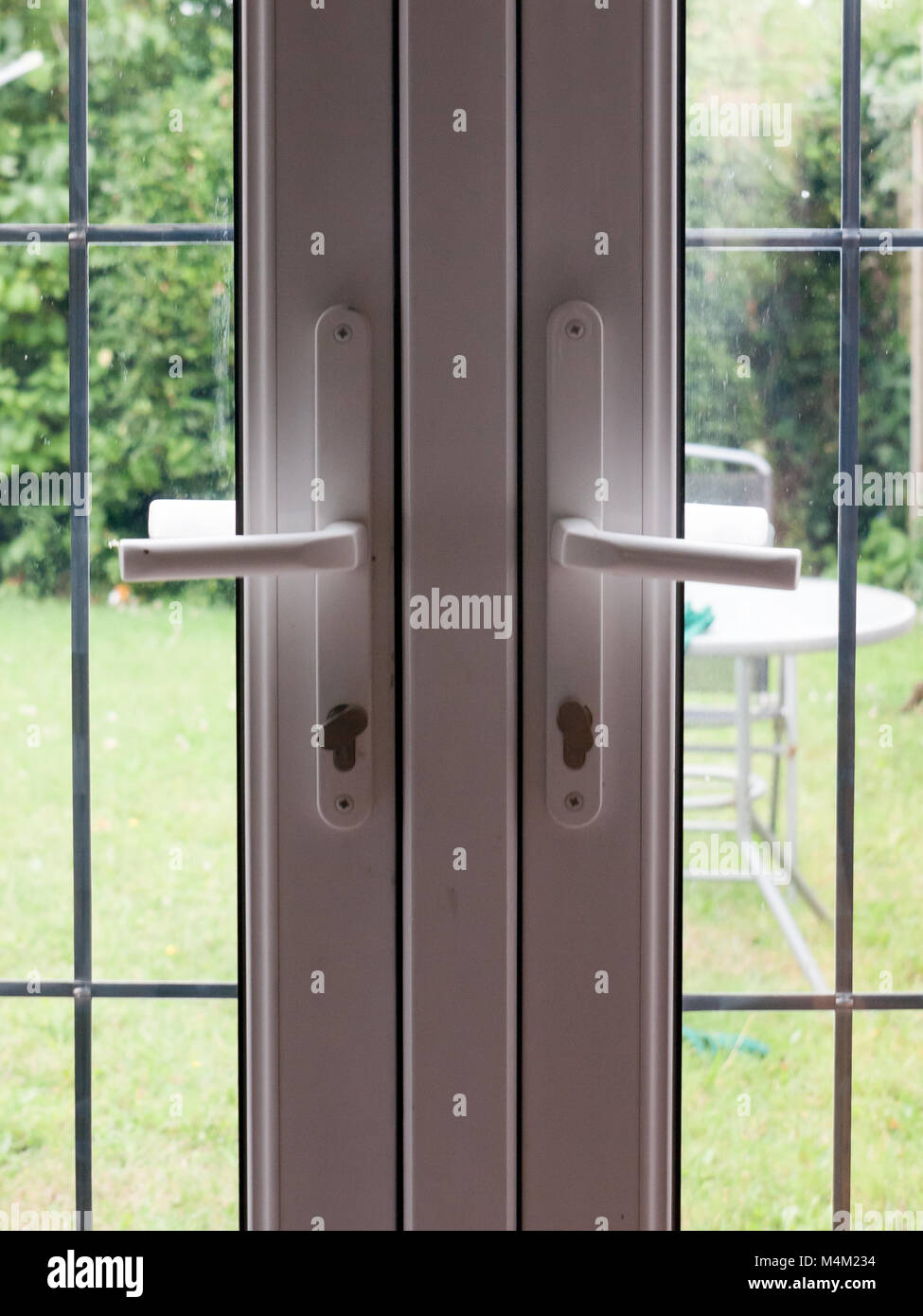 Dos manijas de puerta trasera bloqueada cerca de jardín Fotografía de stock  - Alamy