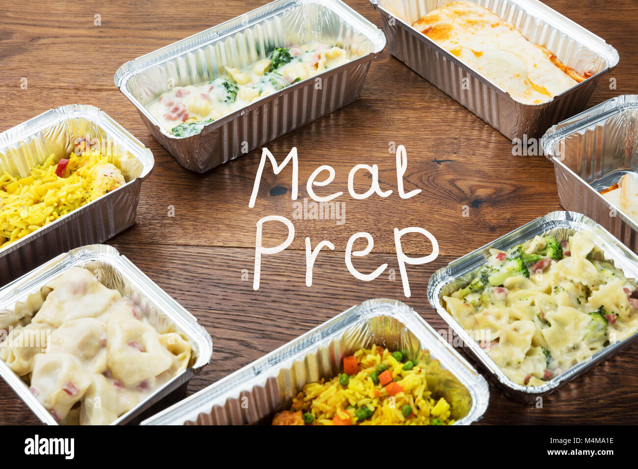 La Palabra escrita de preparación de comida en la mesa con comida para llevar en recipientes de aluminio Foto de stock