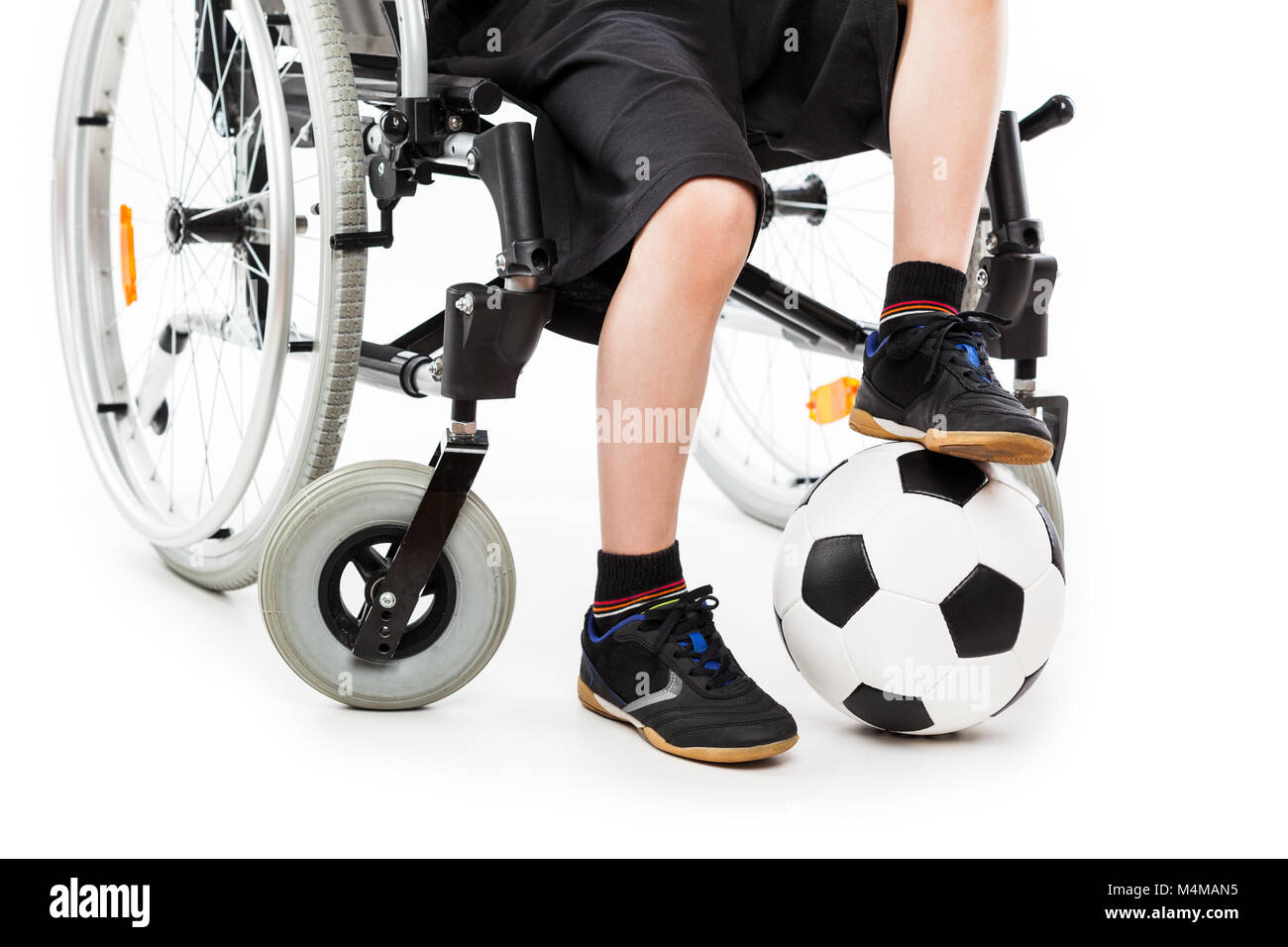 Niño discapacitado muchacho sentado en la silla de ruedas sosteniendo un  balón de fútbol Fotografía de stock - Alamy