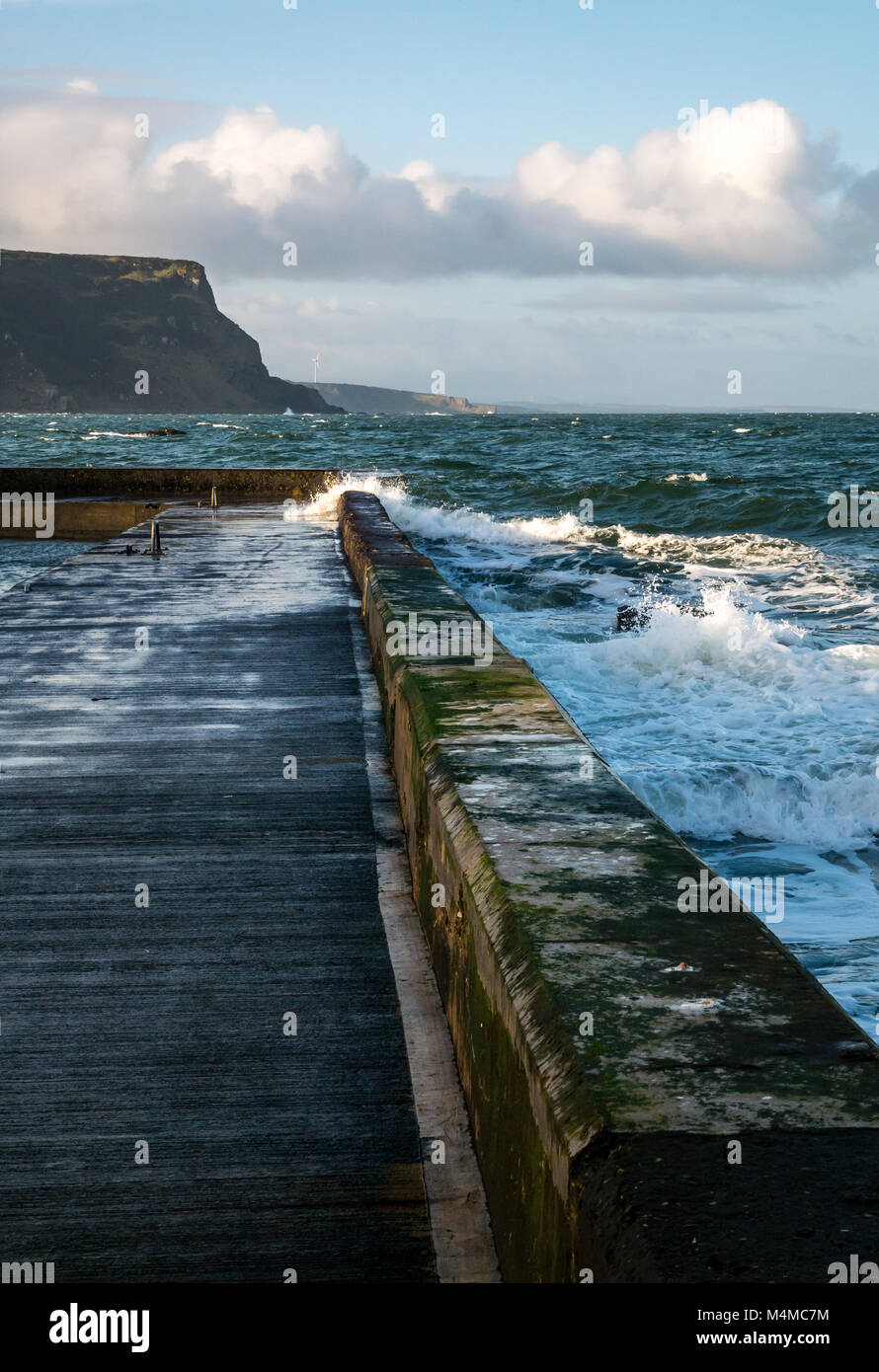 Olas rompiendo en el muelle, localidad costera de Crovie, al noreste de Escocia, Reino Unido Foto de stock