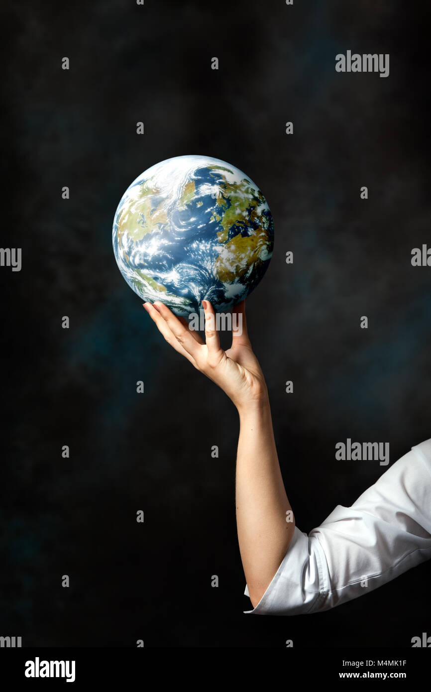 Mujer sosteniendo el planeta Tierra en su mano Foto de stock