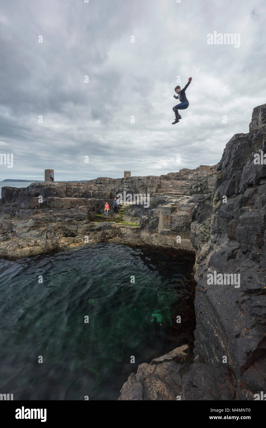 Cliff saltar en la piscina azul, Portrush, Condado de Antrim, Irlanda del Norte. Foto de stock