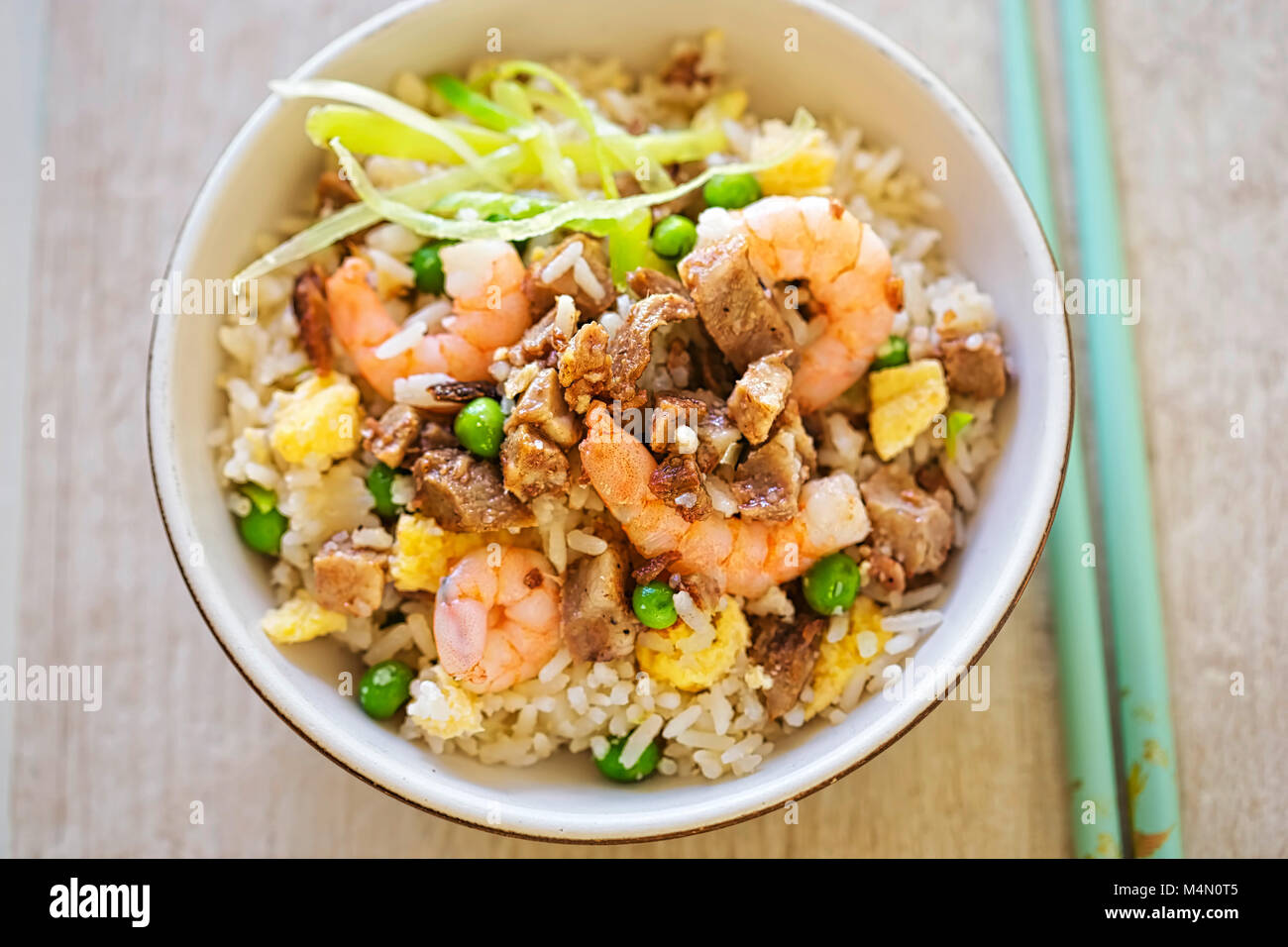 Arroz frito con char sui cerdo, gambas, huevo y verduras con aceite de sésamo Foto de stock