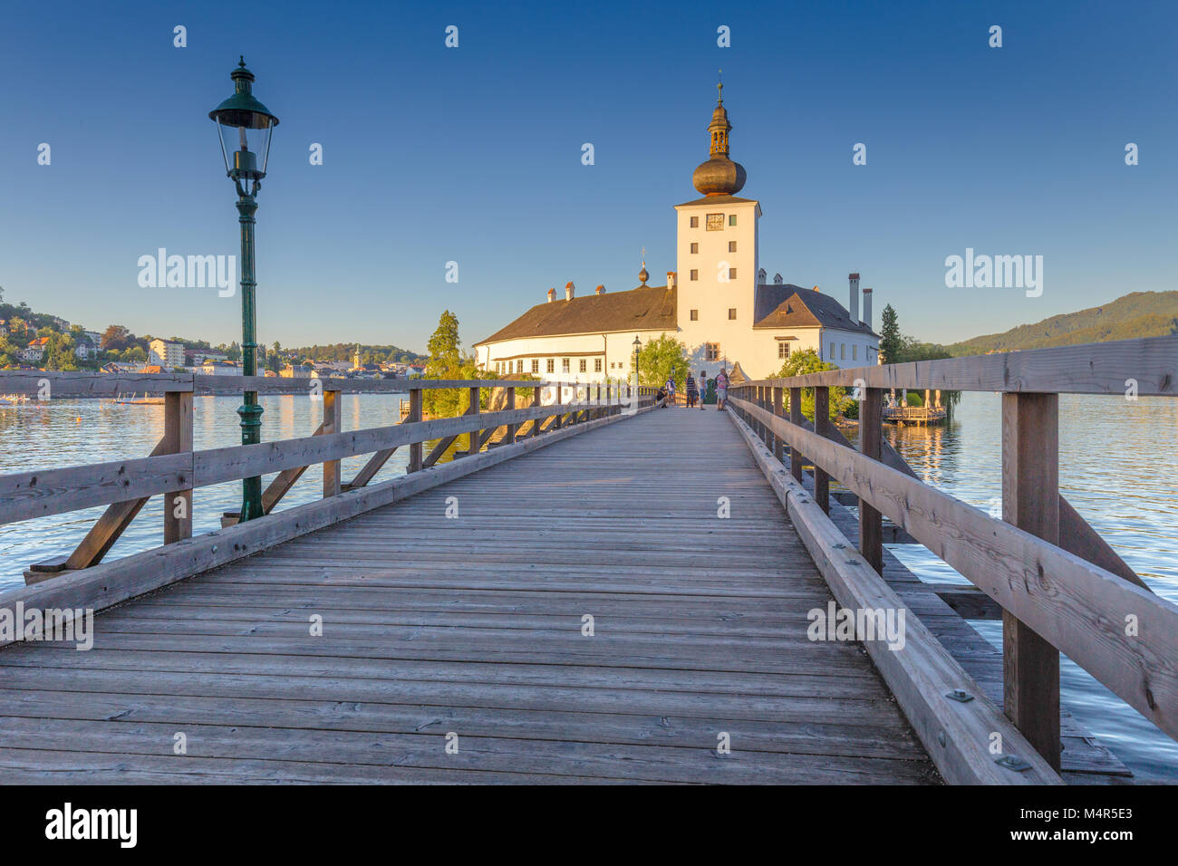 Hermosa vista del famoso Schloss Ort con puente de madera en el lago Traunsee en la hermosa luz del atardecer dorado al atardecer, Gmunden, región de Salzkammergut, una Foto de stock