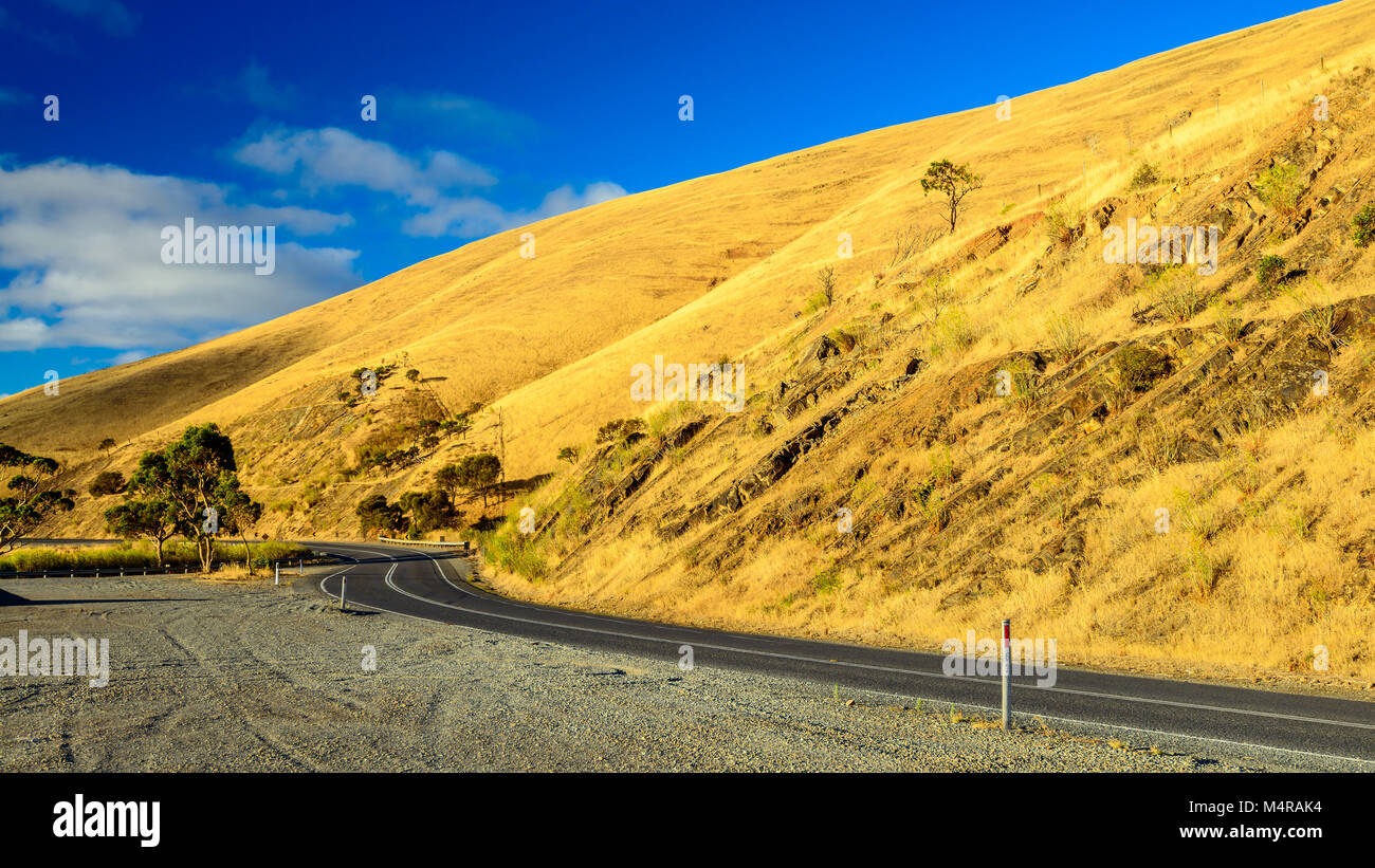Carretera con curvas en las colinas al atardecer cerca de Myponga, South Australia Foto de stock
