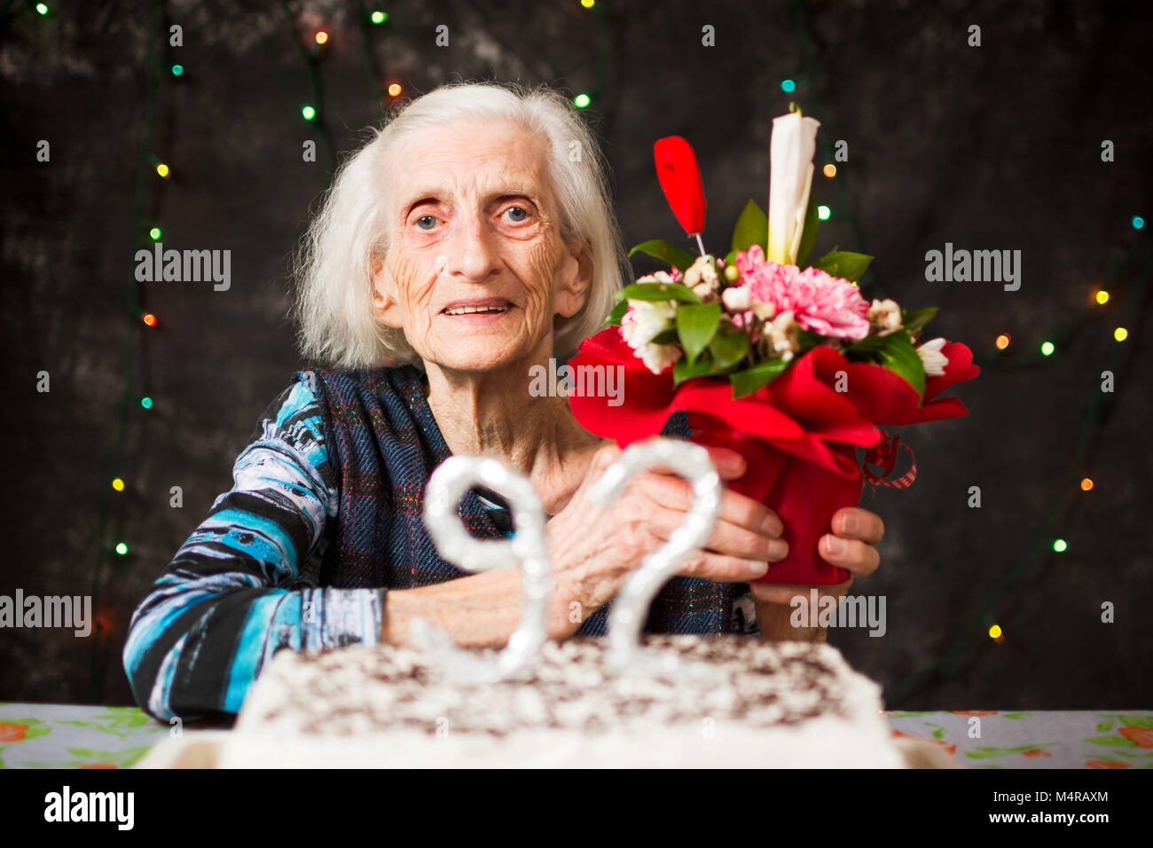 Senior mujer sosteniendo un presente en la fiesta de cumpleaños Foto de stock