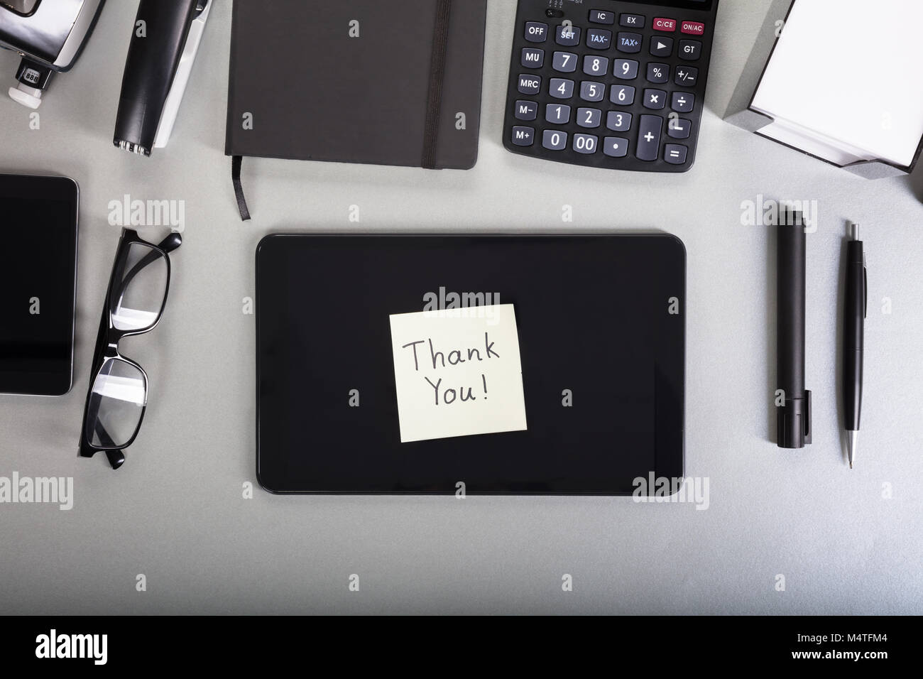 Gracias Nota sobre la tableta digital sobre el escritorio de la oficina Foto de stock