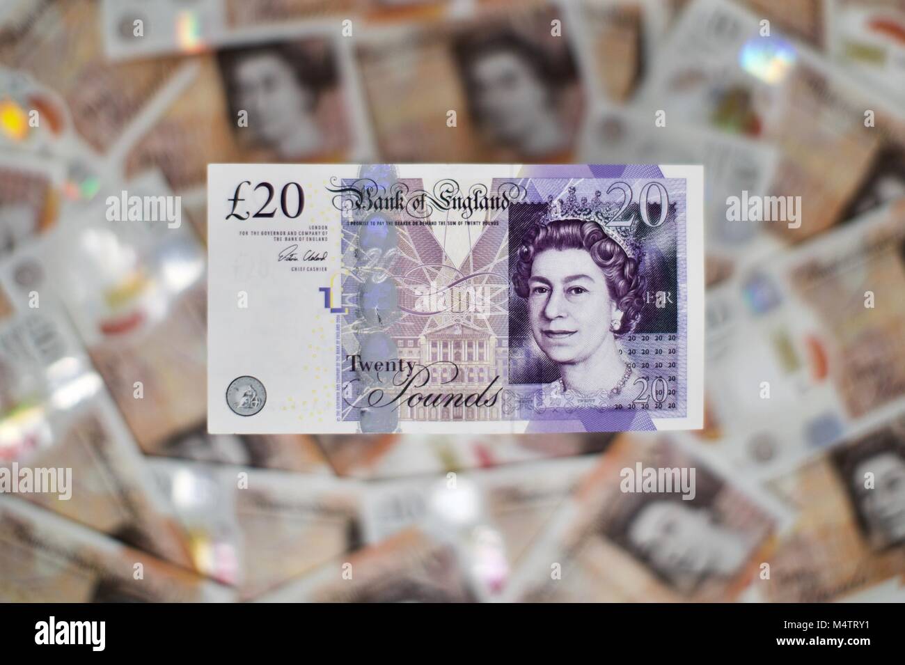 Billetes de 20 libras con los nuevos billetes de diez libras de plástico en el fondo Foto de stock