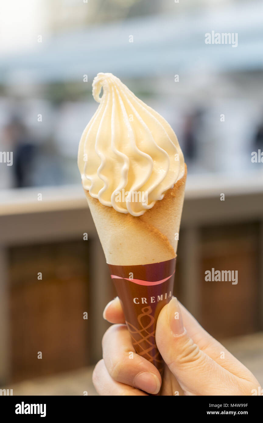 Mano sujetando un cono de helado cremoso Foto de stock