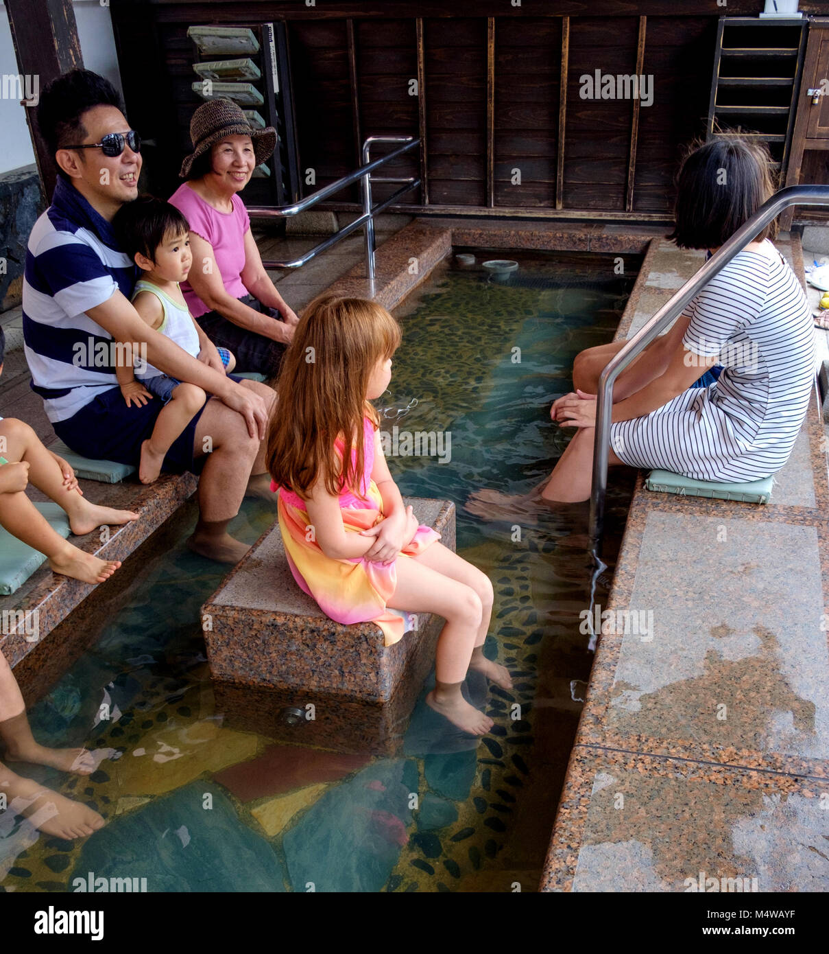 Familia Japonesa Remojar Los Pies En Aguas Termales Baños De Pies Chico Sentado En El Regazo 8918