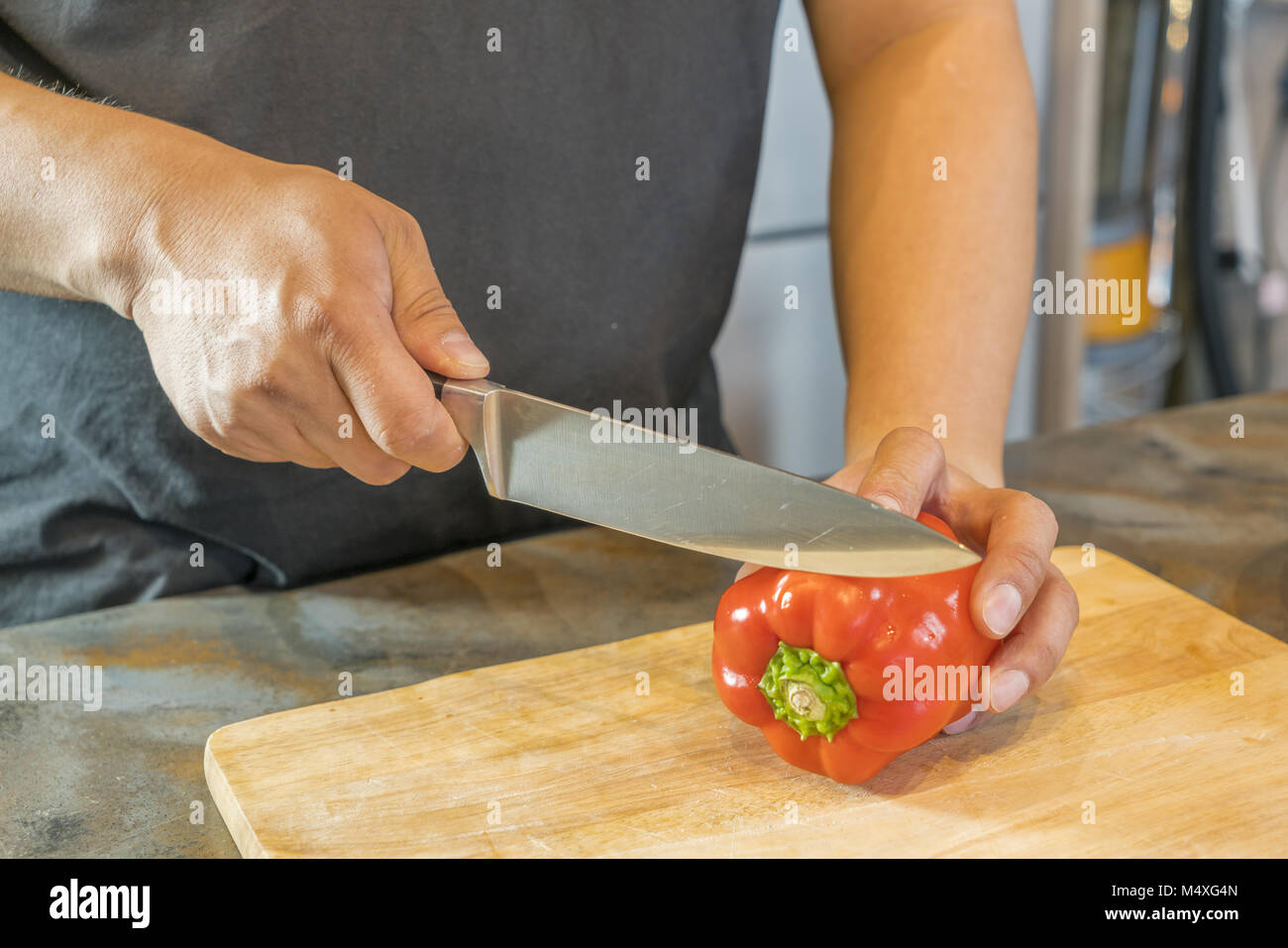 Chef cortar el pimiento rojo en madera amplio Foto de stock