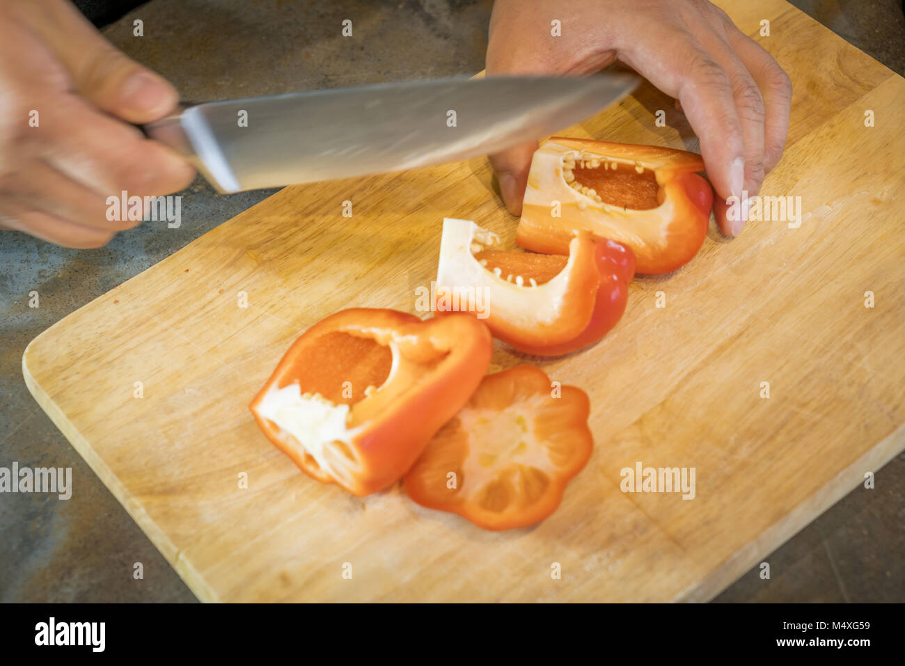 Chef cortar el pimiento rojo en madera amplio Foto de stock