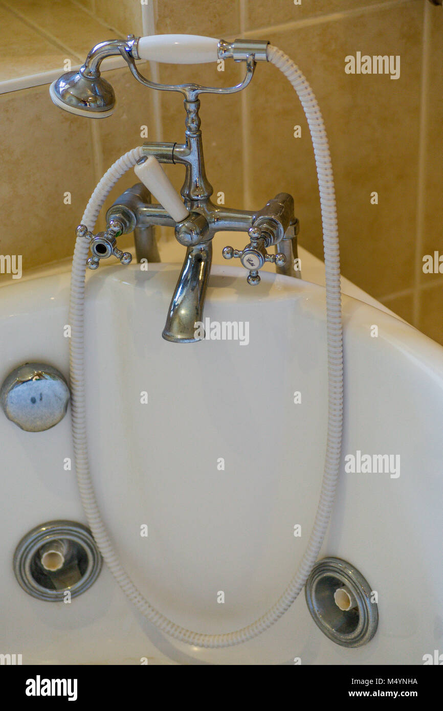 Reposición Deber compañerismo Latón Antiguo grifo mezclador y la alcachofa de la ducha sobre la bañera  Jacuzzi Fotografía de stock - Alamy