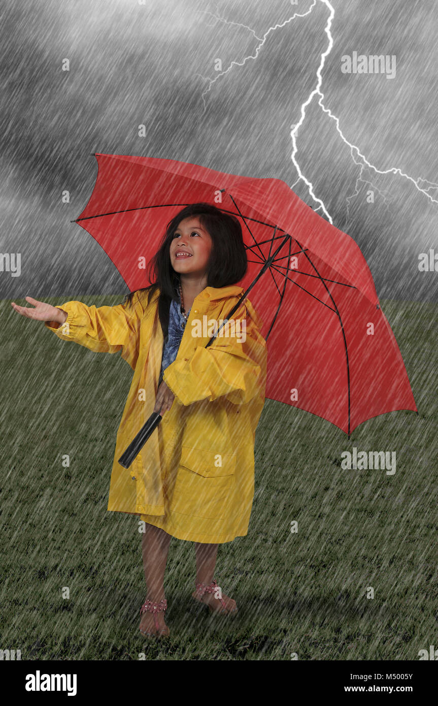 Chica en impermeable sosteniendo paraguas Foto de stock