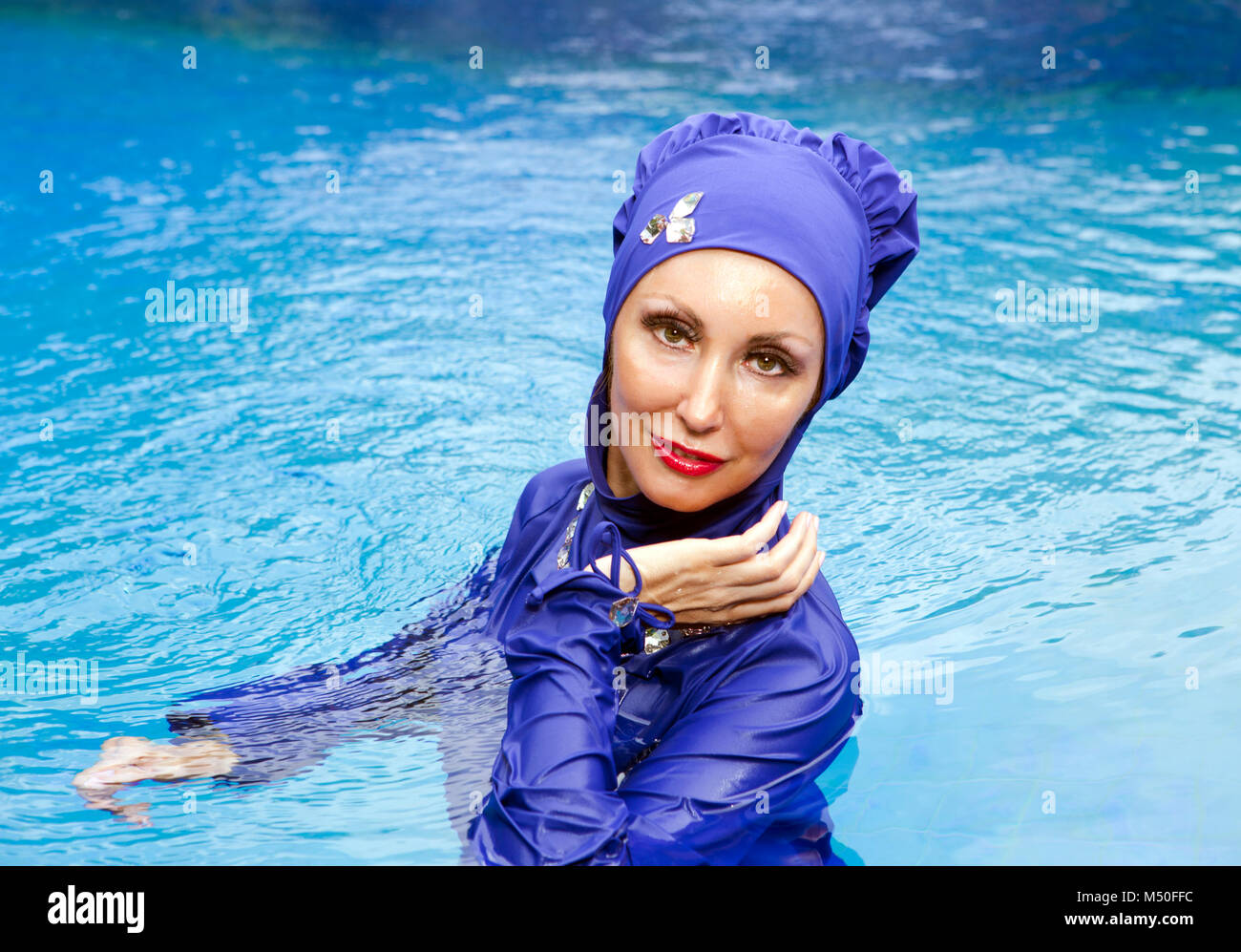 Matar Tratado Asimilación Mujer atractiva en un bañador burkini musulmana se sienta en el borde de la  piscina Fotografía de stock - Alamy