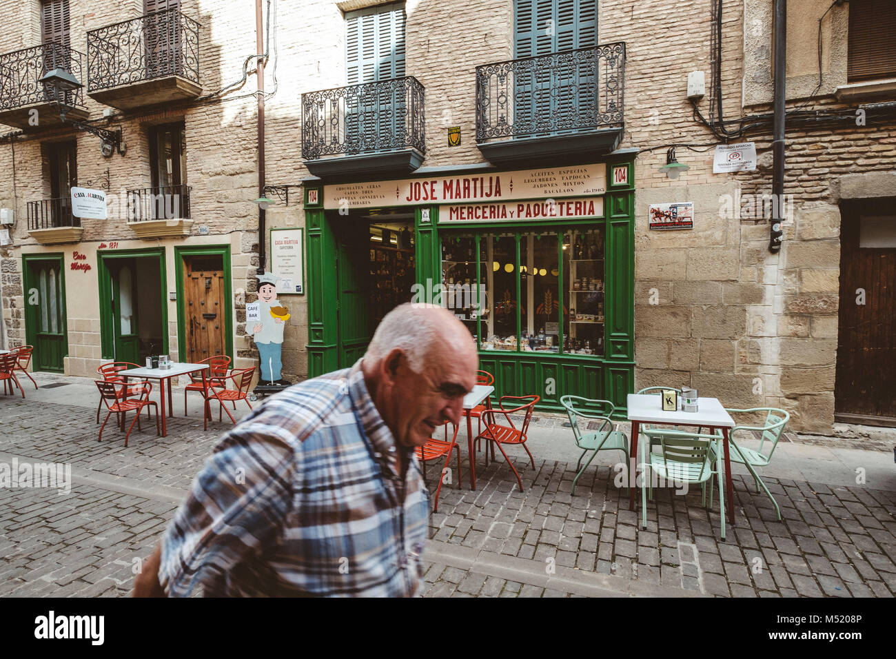 Altos hombre caminando delante de la tienda tradicional en el casco antiguo de Pamplona, Navarra, España Foto de stock