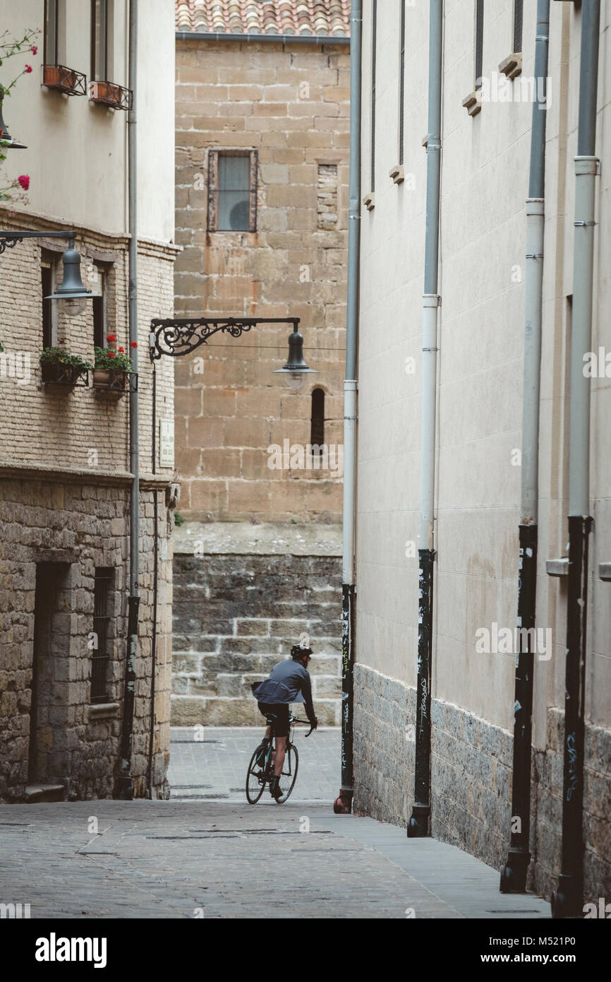 Ciclista caballo Bicicleta calle abajo en el casco antiguo de Pamplona, Navarra, España Foto de stock