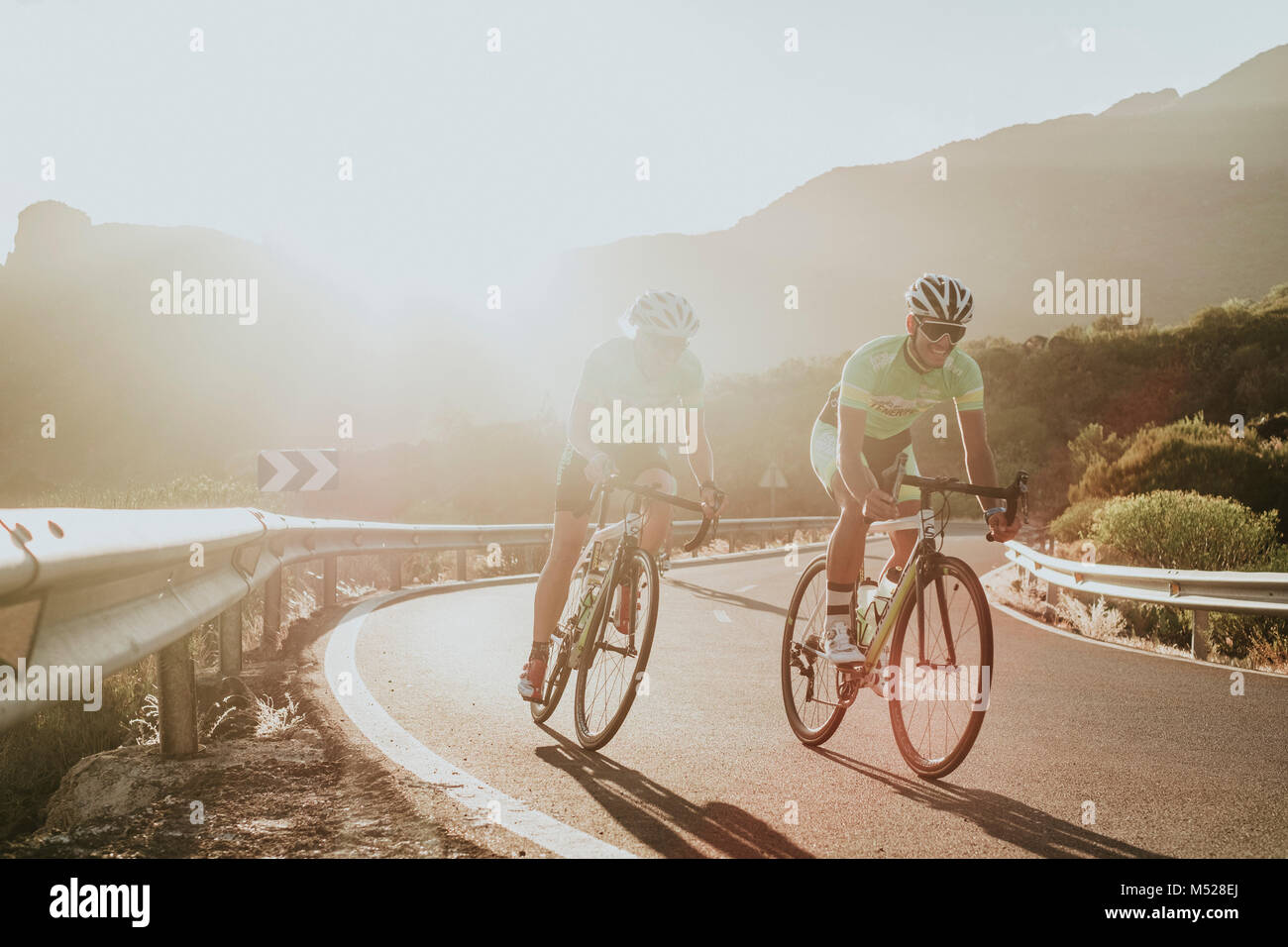 Dos ciclistas pedaleando por la carretera al atardecer, Tenerife, Islas  Canarias, España Fotografía de stock - Alamy