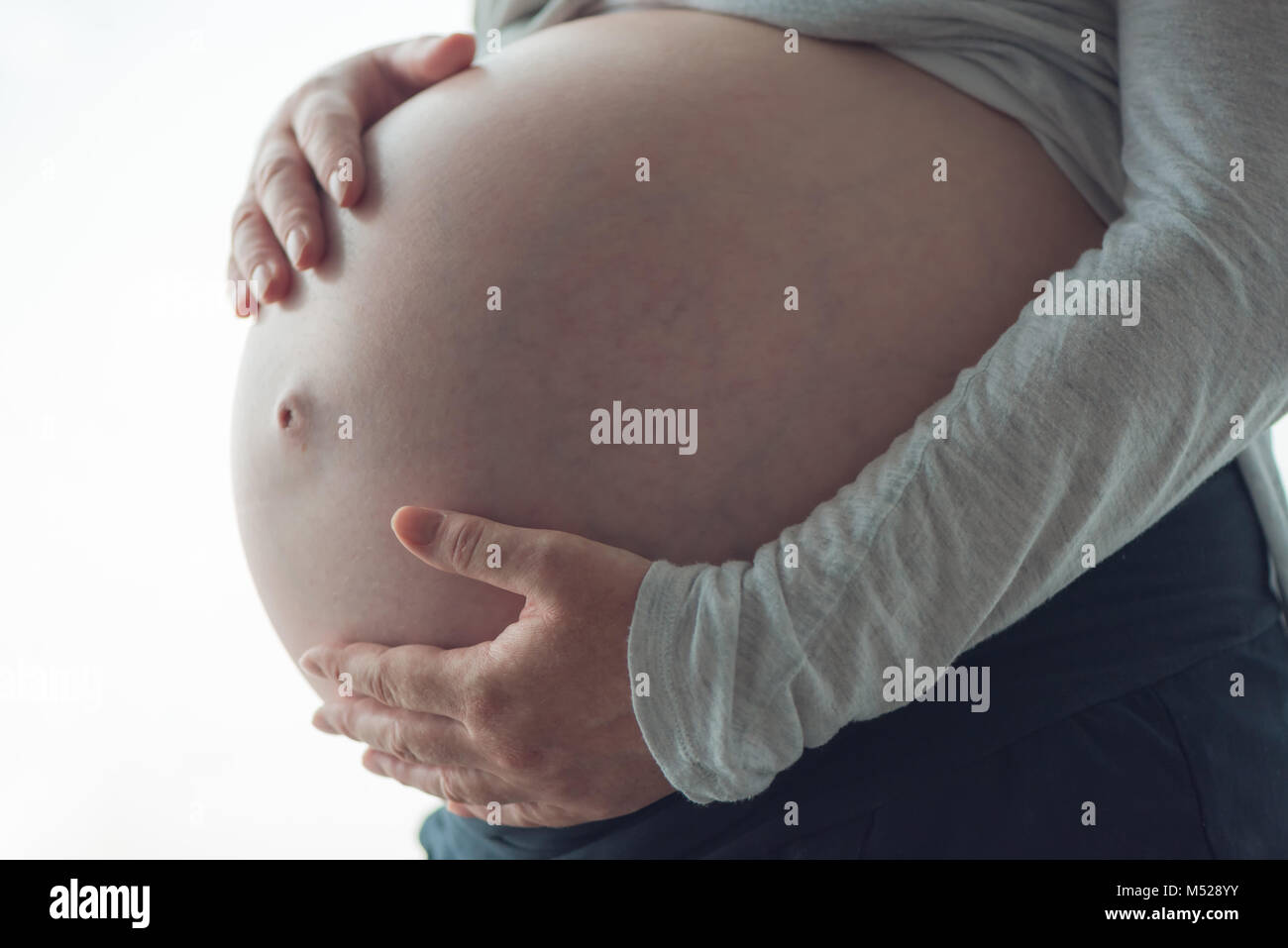 Mujer embarazada barriga, persona de sexo femenino en el noveno mes de embarazo posando Foto de stock