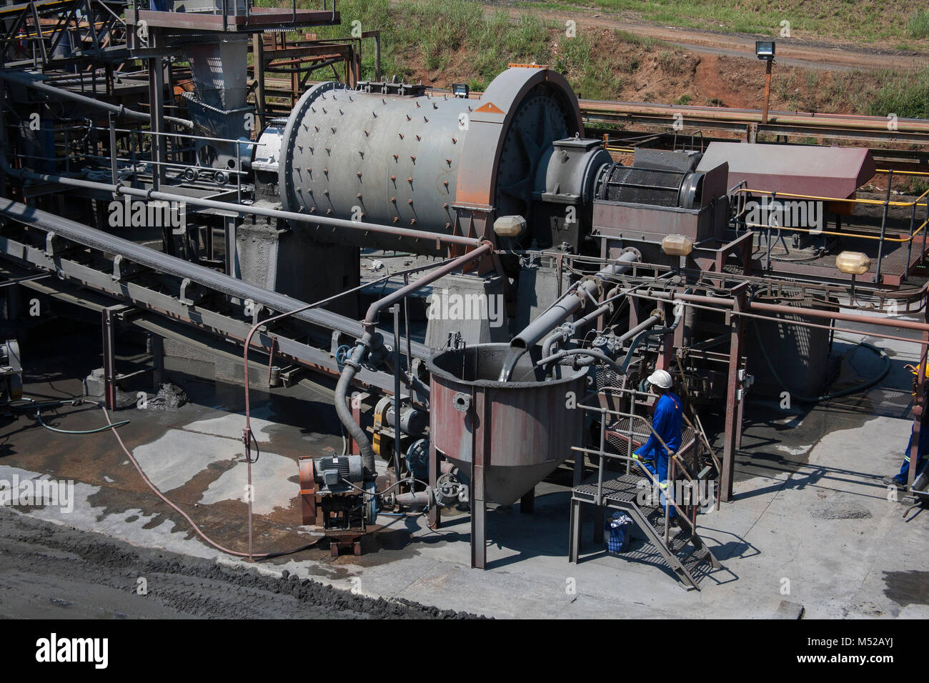 Vista superior de una trituradora y trabajador en una mina entre máquinas en una planta de procesamiento Foto de stock